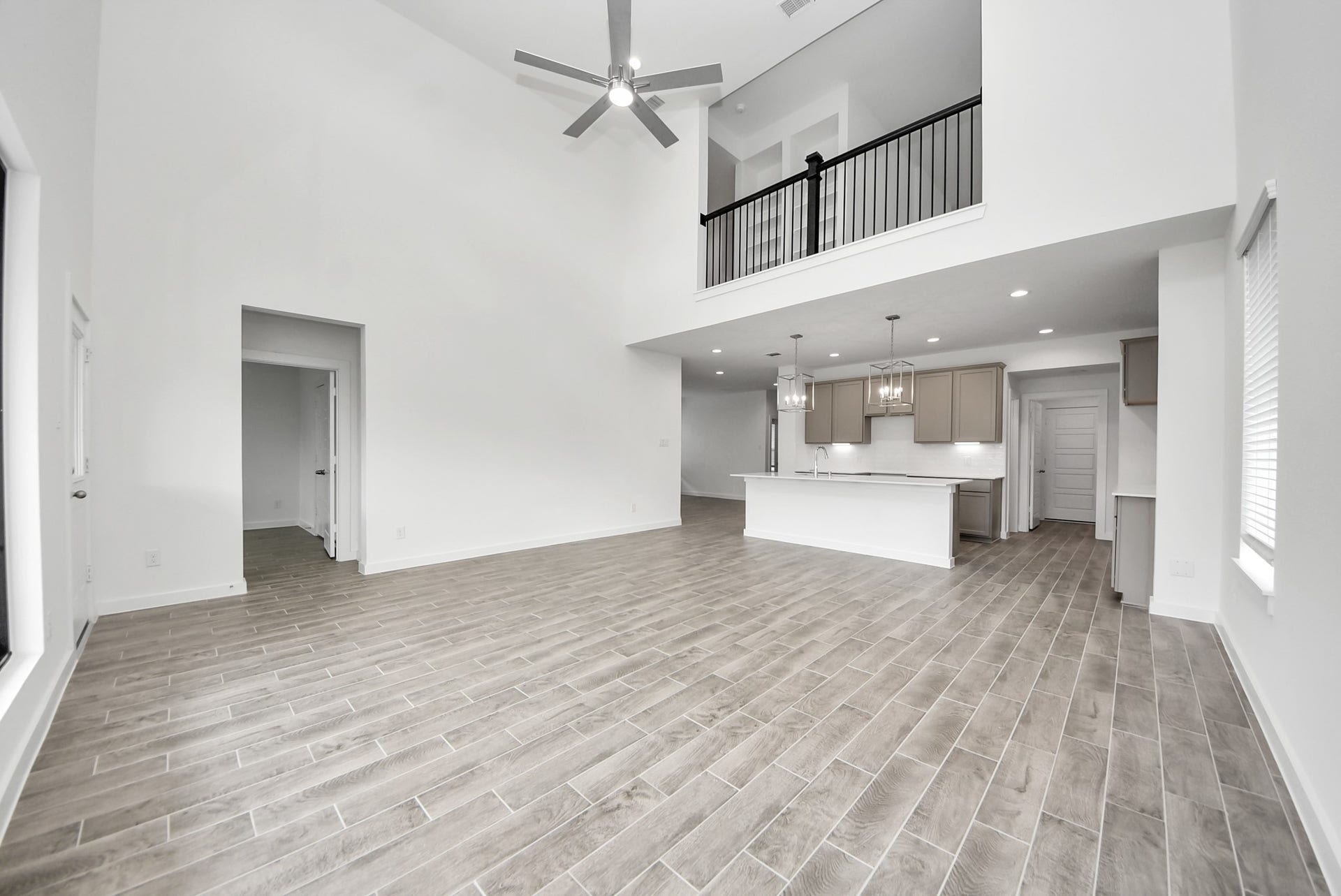 11119 Rose River Drive, Houston, TX 77044 Family room flooded with natural light through the expansive windows. The premium tile flooring adds a touch of luxury to the space, creating the perfect setting for relaxing moments and cherished gatherings with loved ones