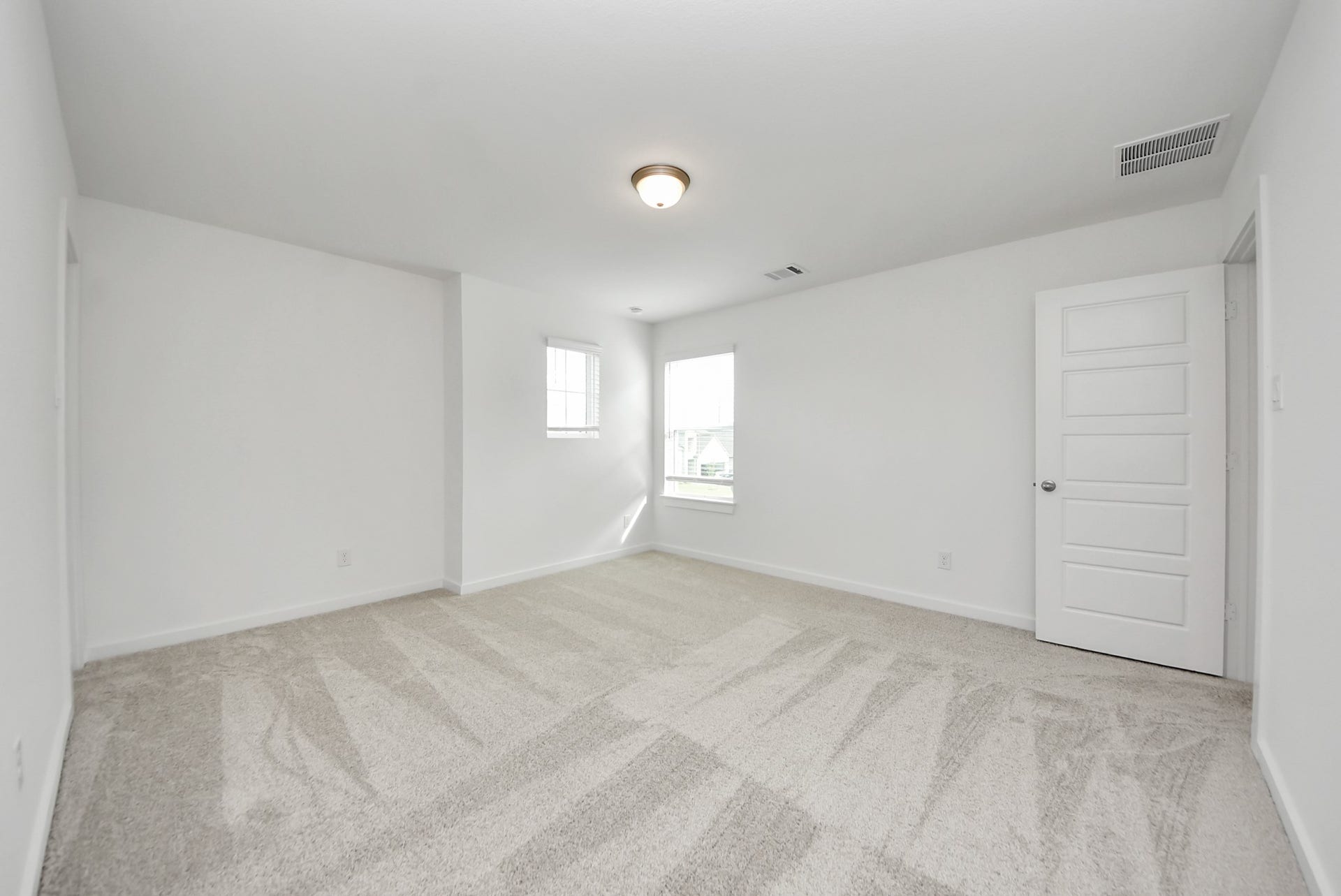 11119 Rose River Drive, Houston, TX 77044 Secondary bedroom features plush carpeting, large windows that let in plenty of natural light, bright paint, and spacious closets.