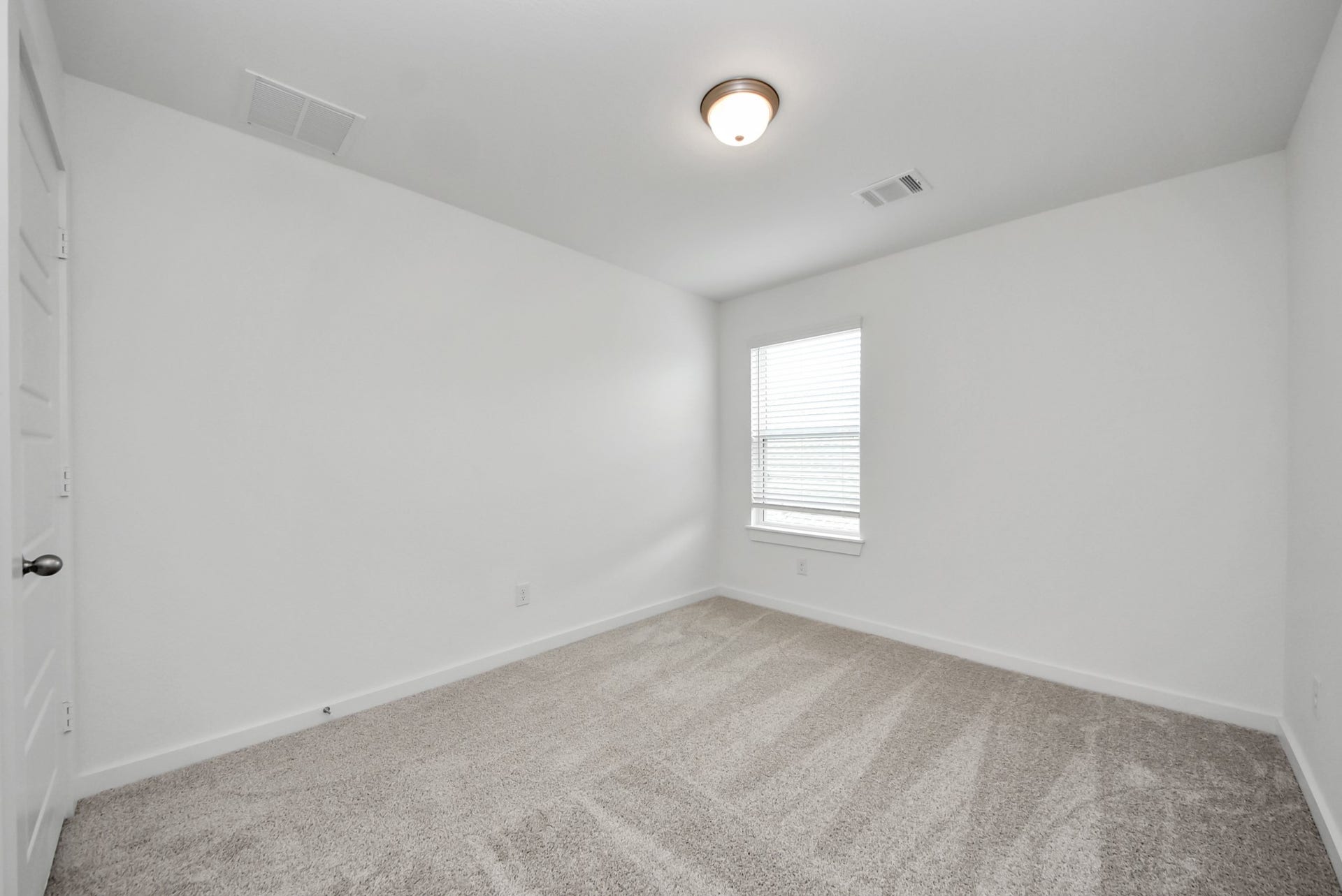 11119 Rose River Drive, Houston, TX 77044 Secondary bedroom features plush carpeting, large windows that let in plenty of natural light, bright paint, and spacious closets.
