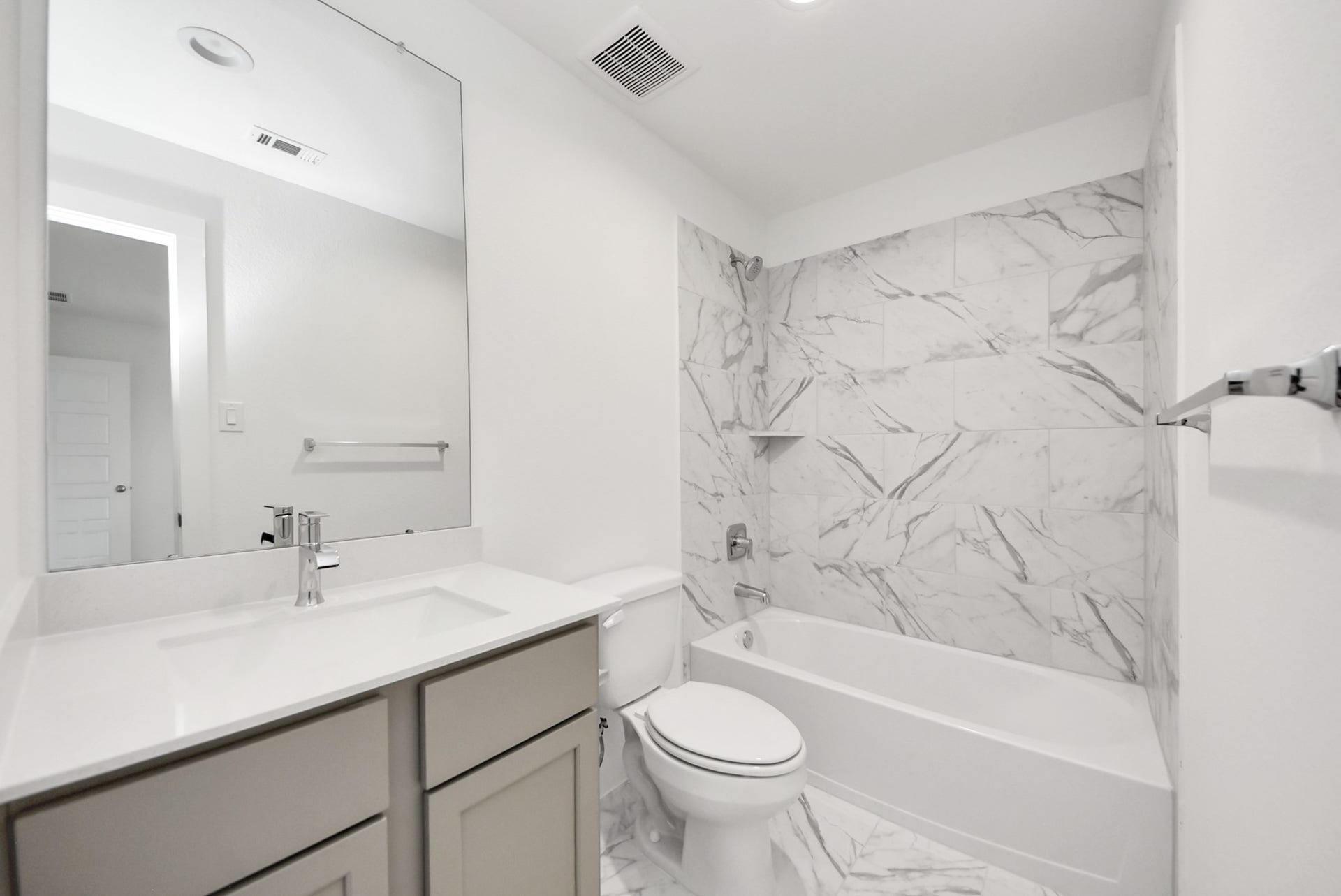 11119 Rose River Drive, Houston, TX 77044 Secondary bath features tile flooring, bath/shower combo with tile surround, light stained wood cabinets, beautiful light countertop.