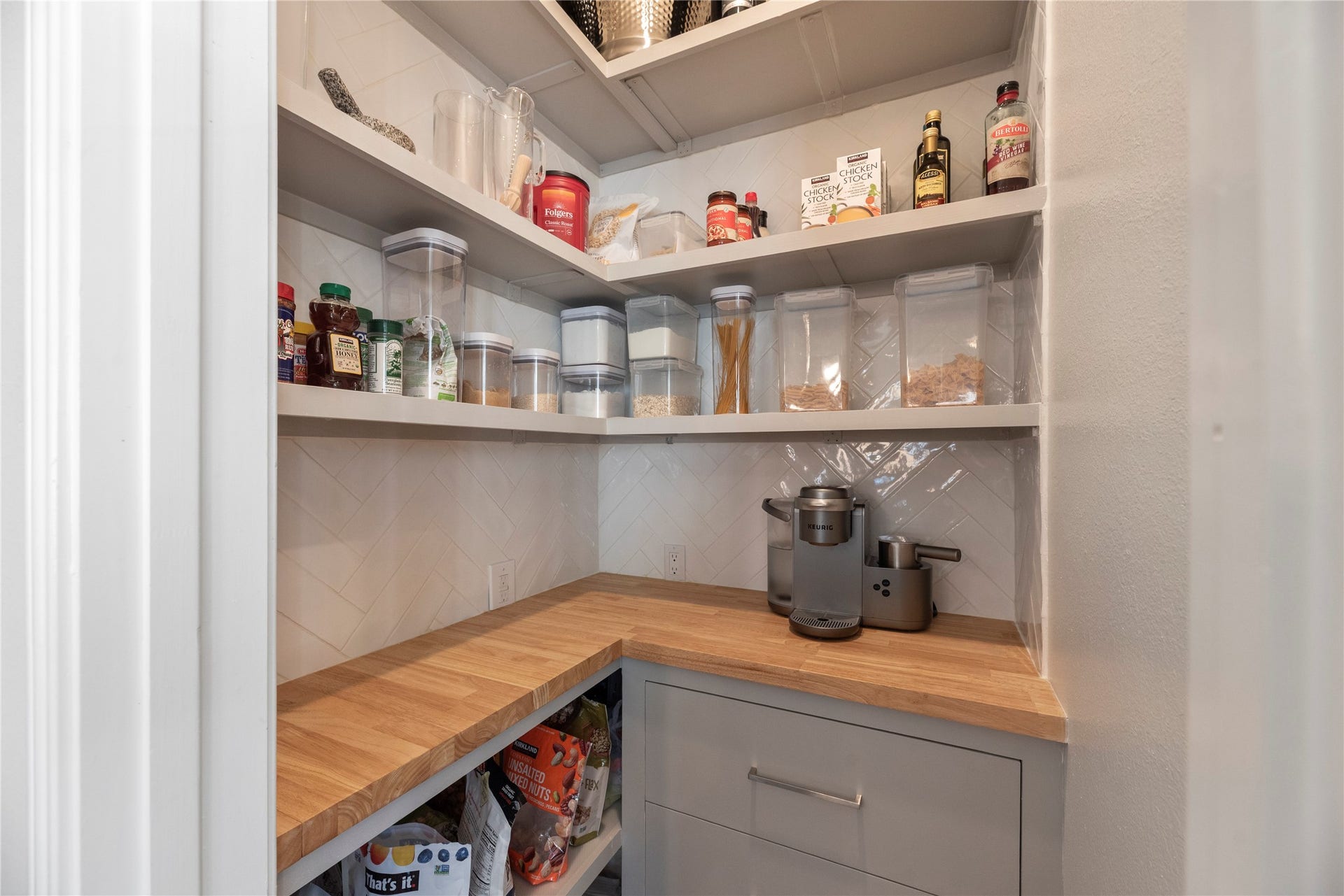 12914 Catfish River Court, Cypress, TX 77433 A well-organized pantry with custom built-ins and countertop, shelves, and a variety of storage solutions for food storage.