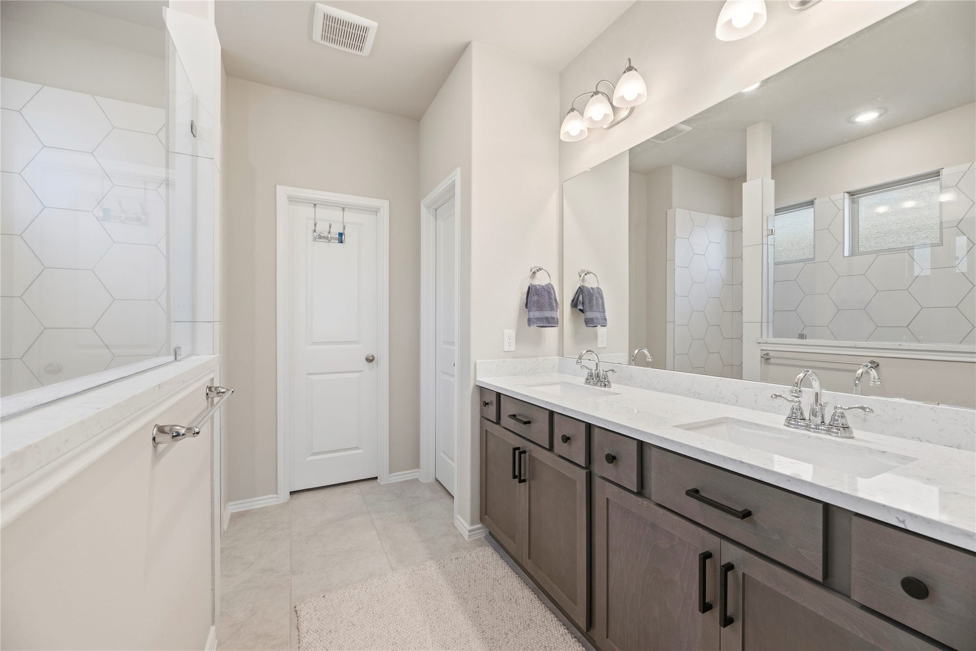 12914 Catfish River Court, Cypress, TX 77433 Primary bathroom with a spacious double vanity featuring a large walk-in shower, sleek quartz countertops and wood cabinets.