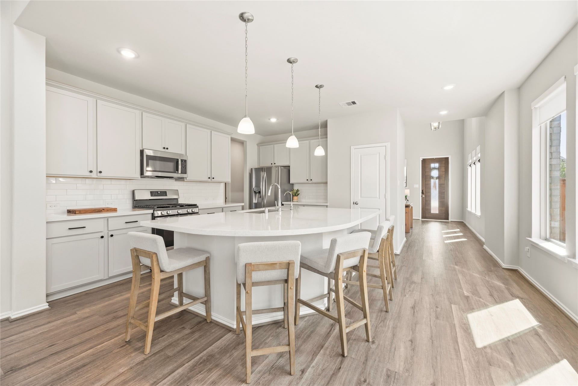12914 Catfish River Court, Cypress, TX 77433 This modern kitchen features a spacious open layout with an island with quartz countertops and stainless steel appliances.
