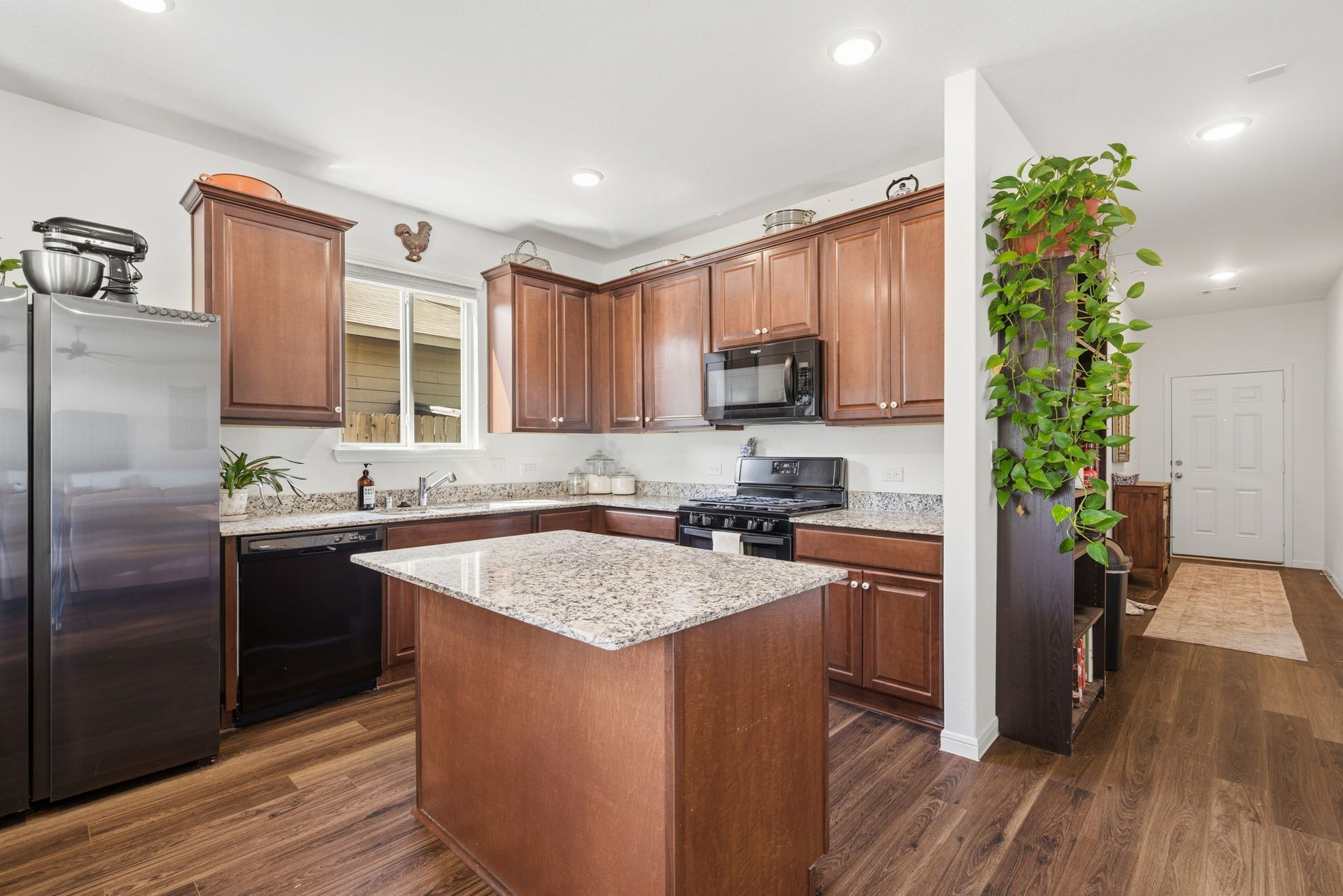 122 Ashwood Glade Lane, Conroe, TX 77378 Elegant kitchen with rich wood cabinetry, granite countertops, and a central island. Stainless steel appliances and a cozy layout make it perfect for cooking and entertaining.