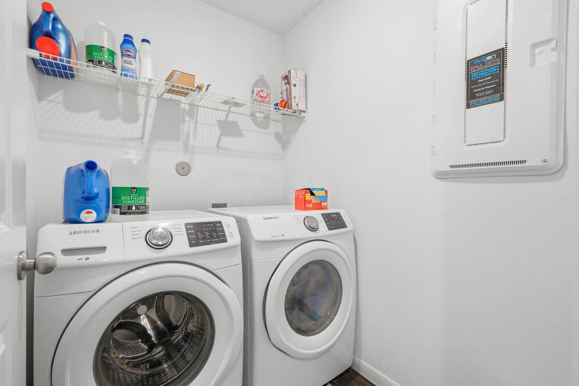 122 Ashwood Glade Lane, Conroe, TX 77378 Modern laundry room featuring Samsung washer and dryer with overhead shelving for convenient storage.