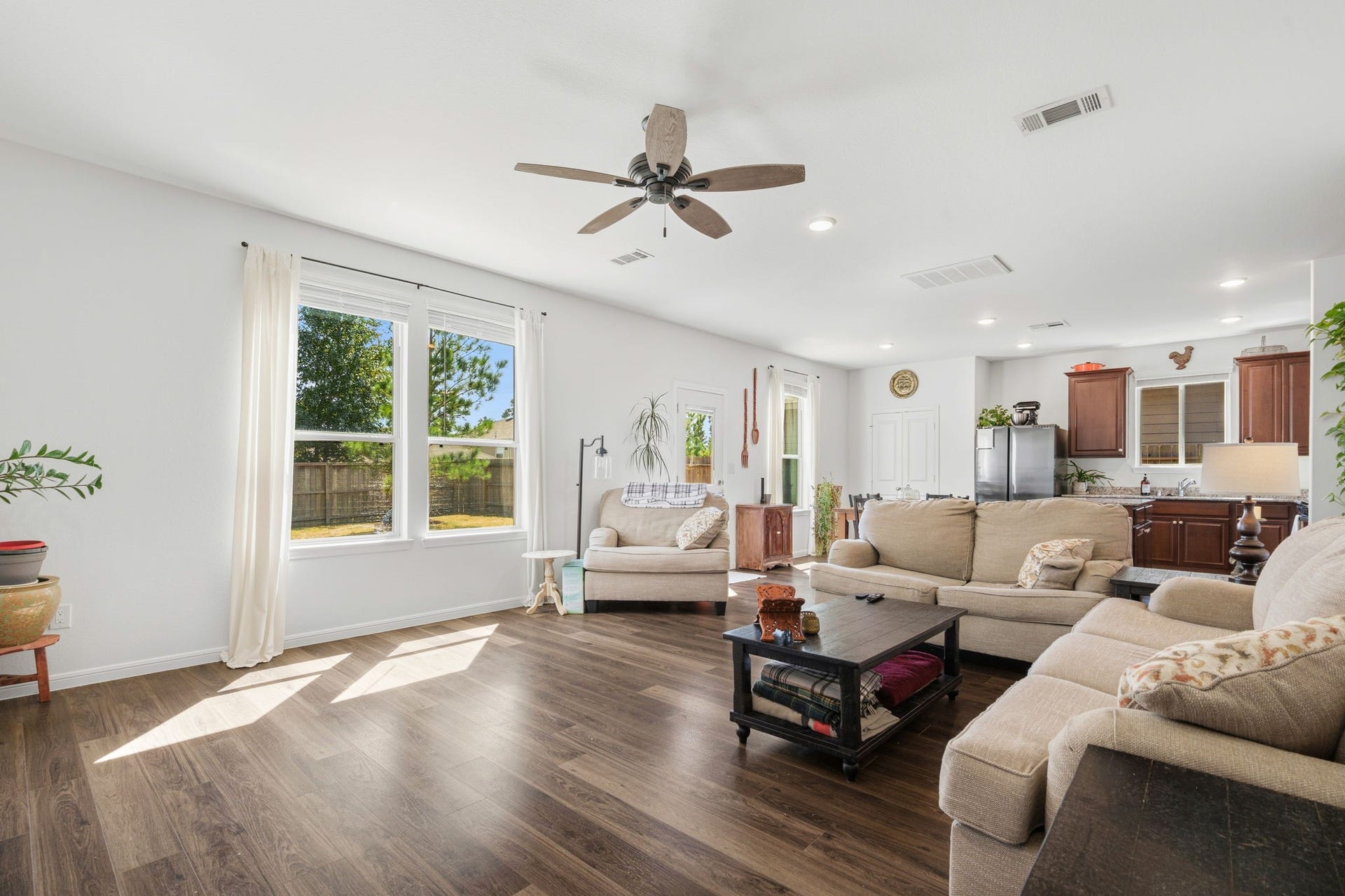 122 Ashwood Glade Lane, Conroe, TX 77378 Spacious living area with abundant natural light, elegant hardwood floors, and a seamless flow into the kitchen, perfect for entertaining and relaxation.