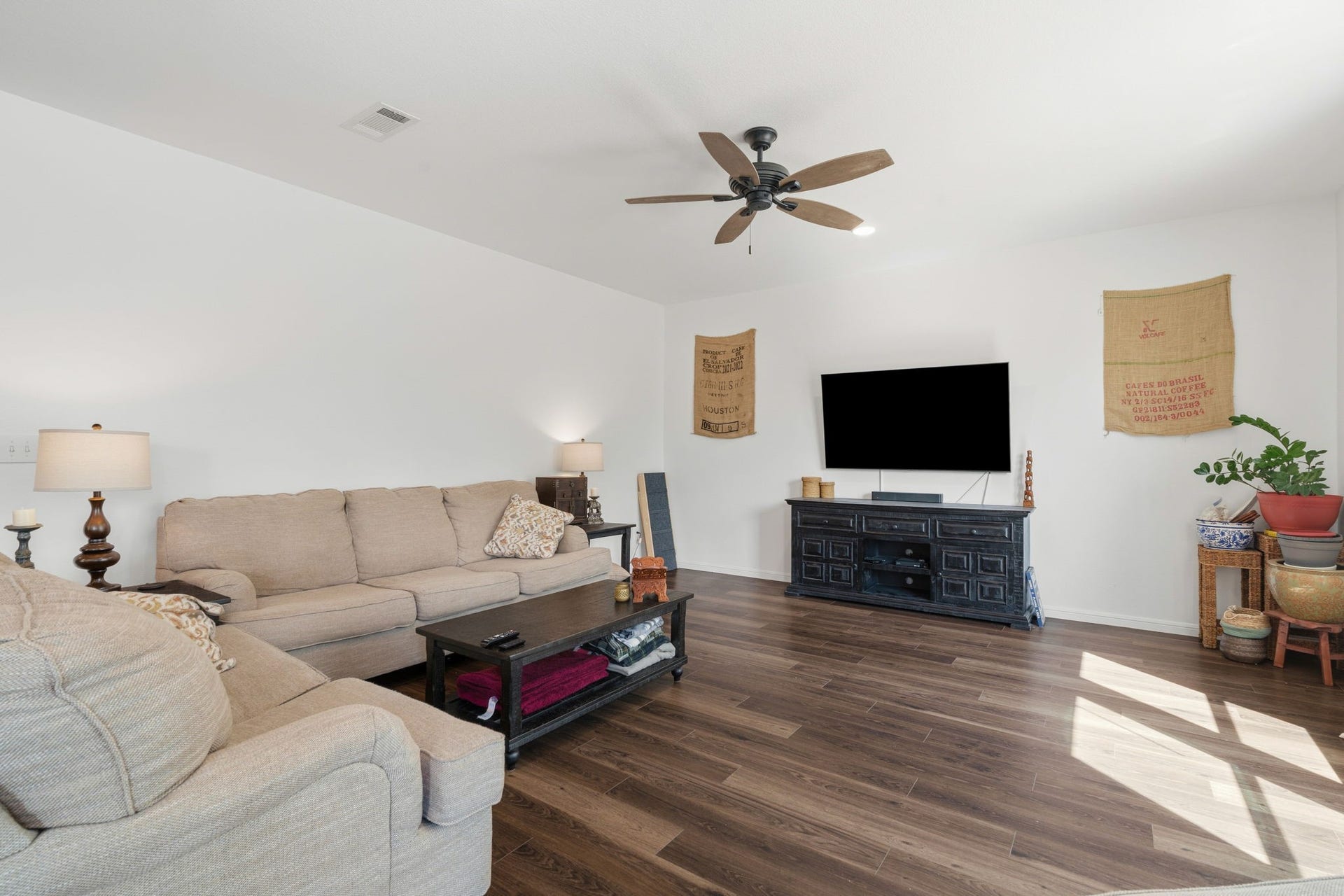 122 Ashwood Glade Lane, Conroe, TX 77378 Spacious living room featuring elegant hardwood floors, a cozy sofa set, and a stylish entertainment center.