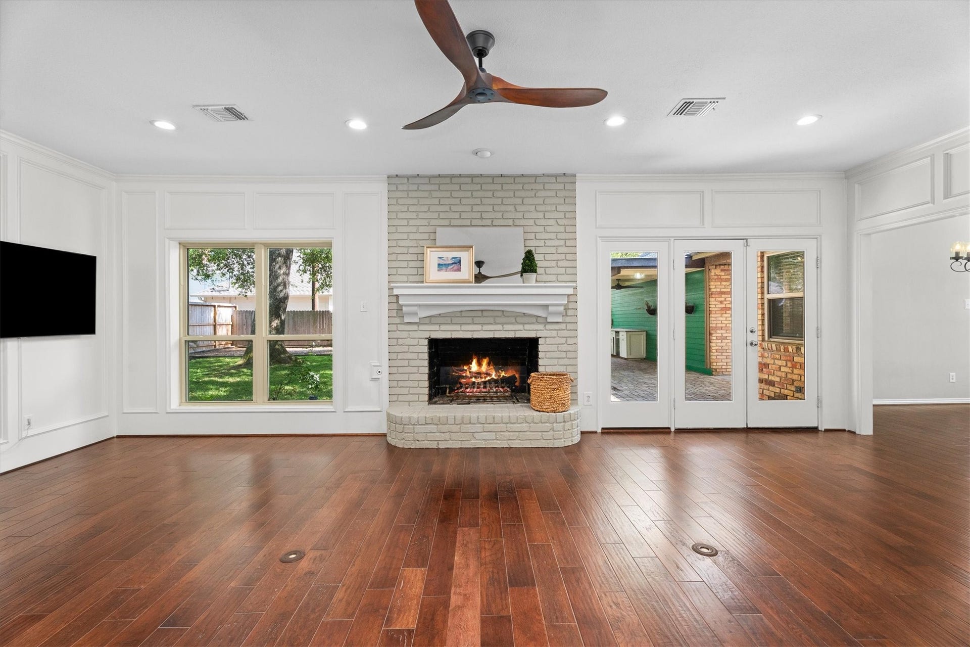 The spacious, open family room is the heart of this home, anchored by a fireplace and a view of the lush backyard.