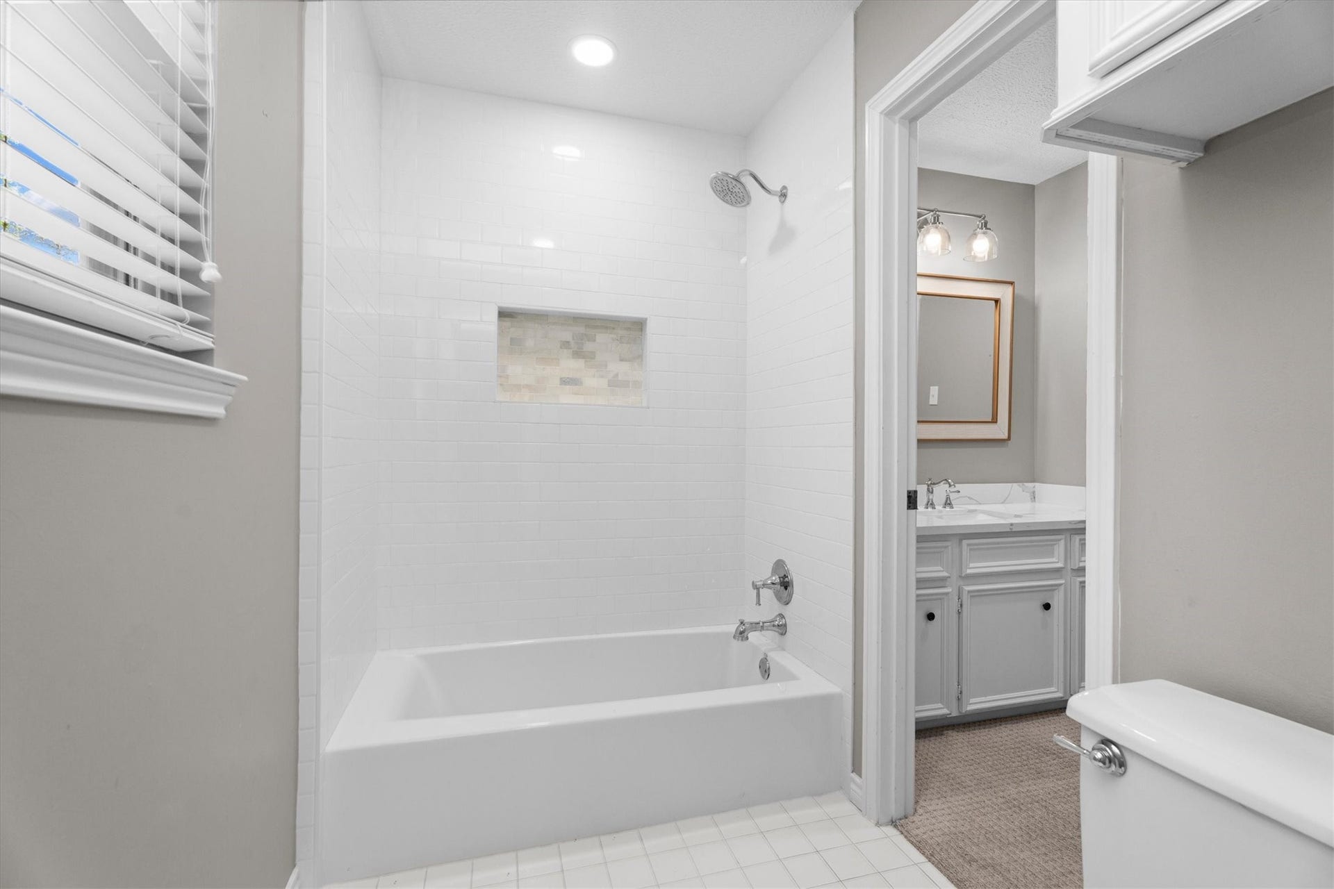 A shared shower/tub combo between the jack-and-jill sinks also features updated tile and fixtures.