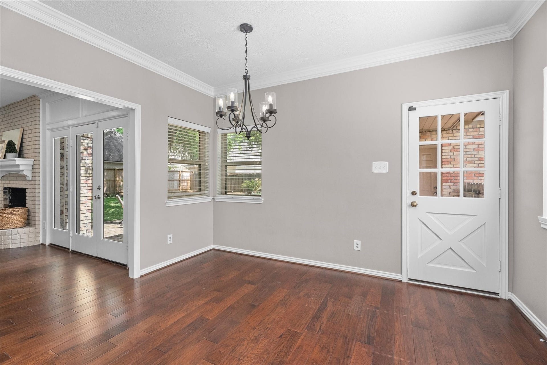 Updated windows anchor this sunny breakfast room. The back door opens to a covered walkway to the three-car garage.