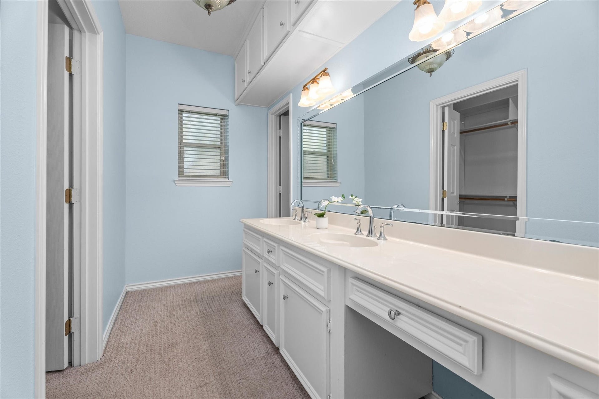 The primary bath vanity features double sinks and a long vanity space, plus extensive upper and lower storage.