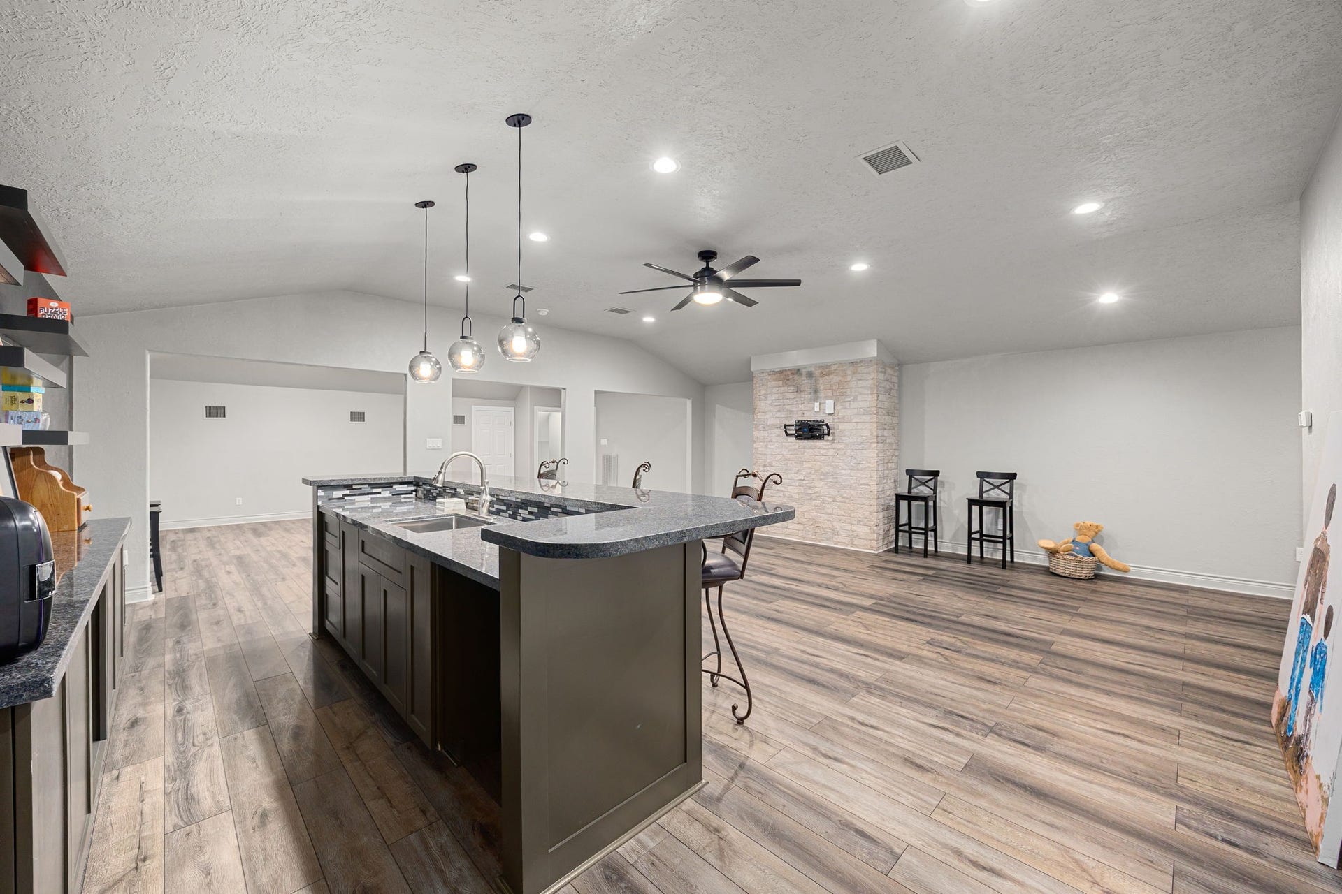 11956 White Oak Crossing, Conroe, TX 77385 Game Room features a stylish wet bar, floating shelves, and ample storage cabinetry.