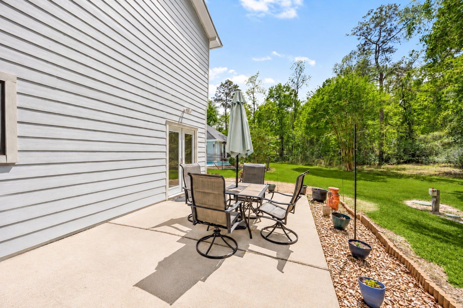 11956 White Oak Crossing, Conroe, TX 77385 Private spacious patio area adjacent to the detached guest house, perfect for outdoor dining and relaxation.
