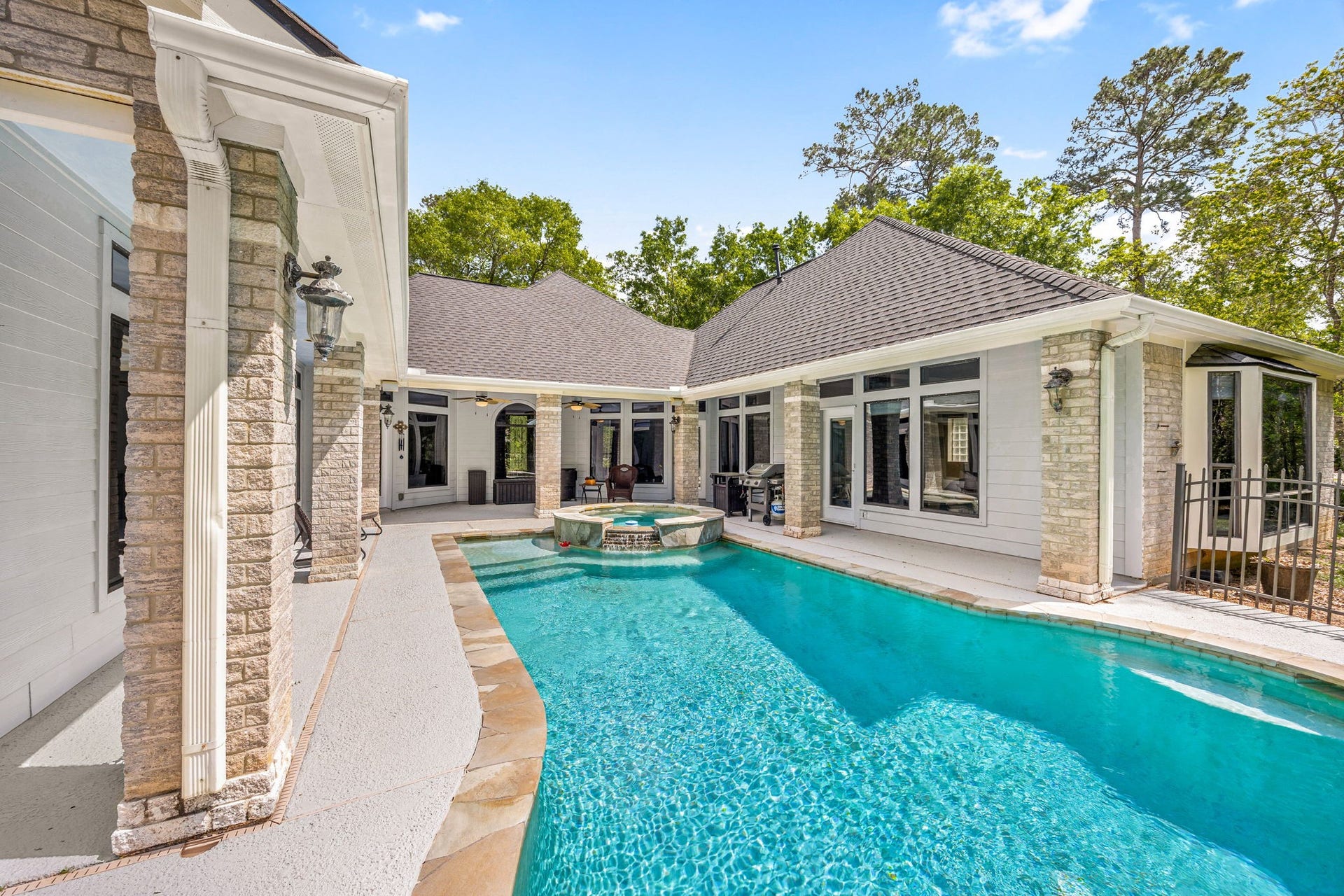 11956 White Oak Crossing, Conroe, TX 77385 The pool is fully fenced with rod iron fencing allowing for views of the landscaped yard while swimming.
