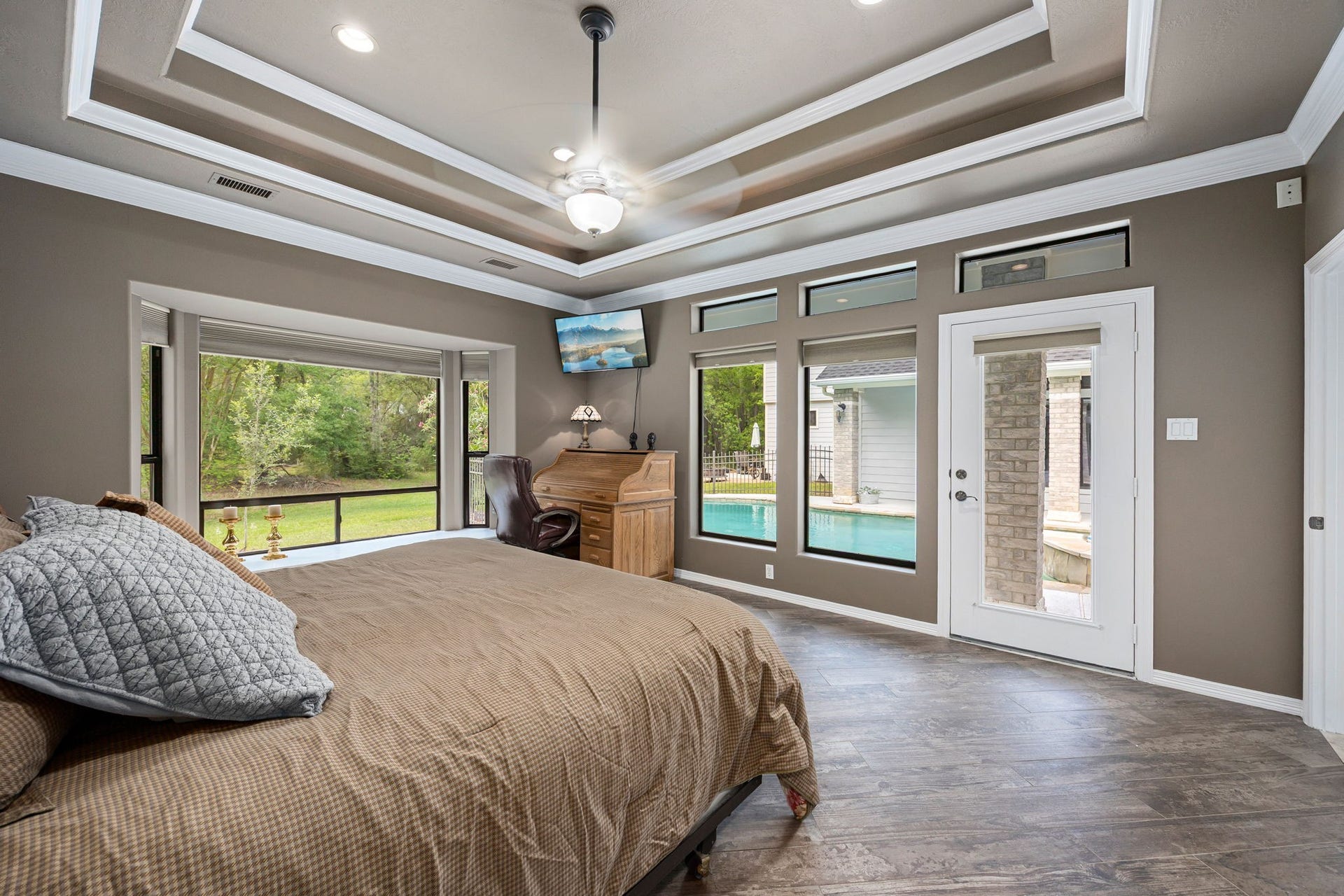 11956 White Oak Crossing, Conroe, TX 77385 Spacious primary suite featuring expansive windows providing a beautiful, serene views of the yard and pool.