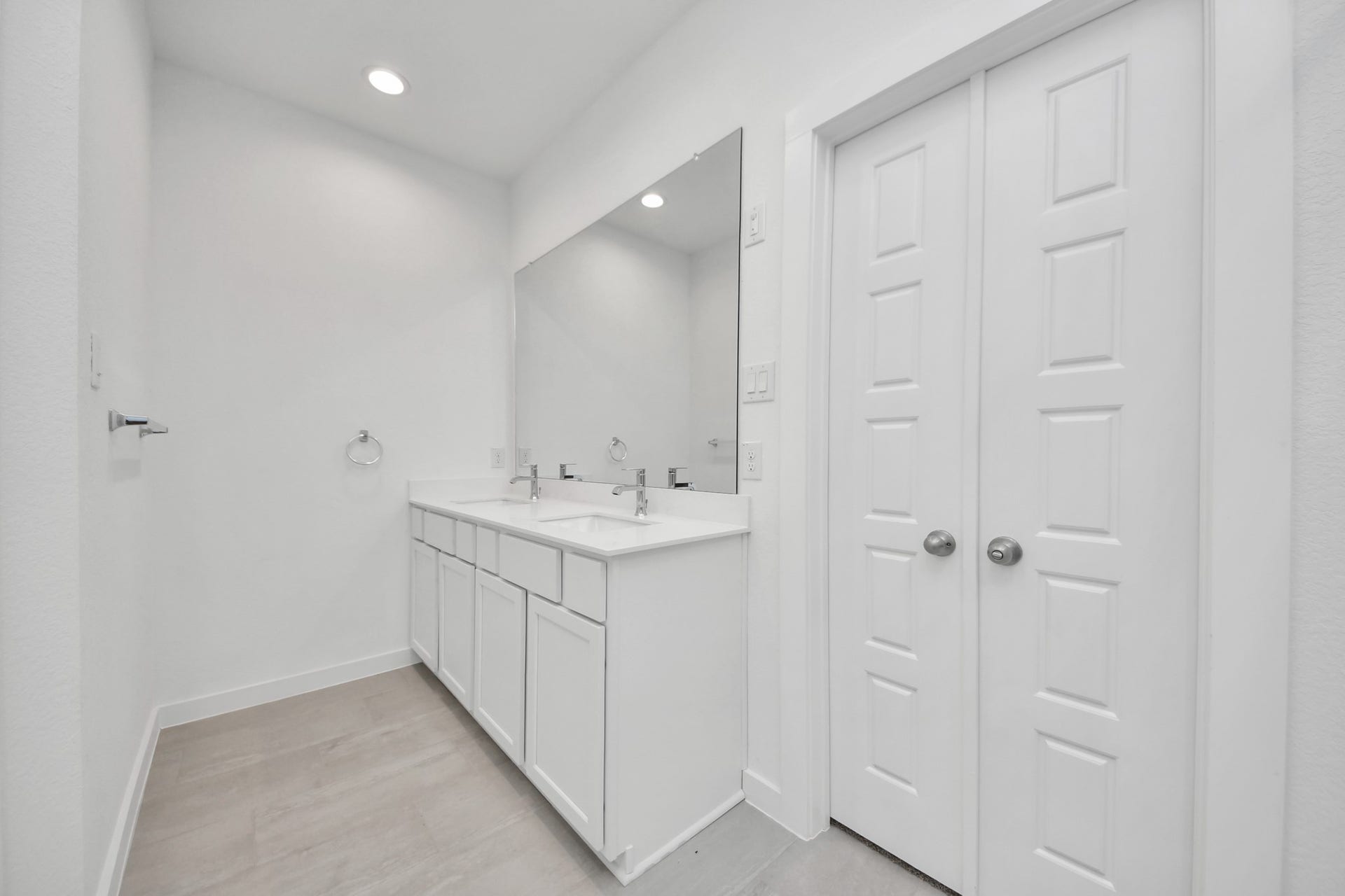 Elevate your daily routine at the elegant vanity, now equipped with double sinks, light countertops, modern hardware, and beautiful recessed lights. Sample photo of completed home with similar floor plan. Actual colors and selections may vary.
