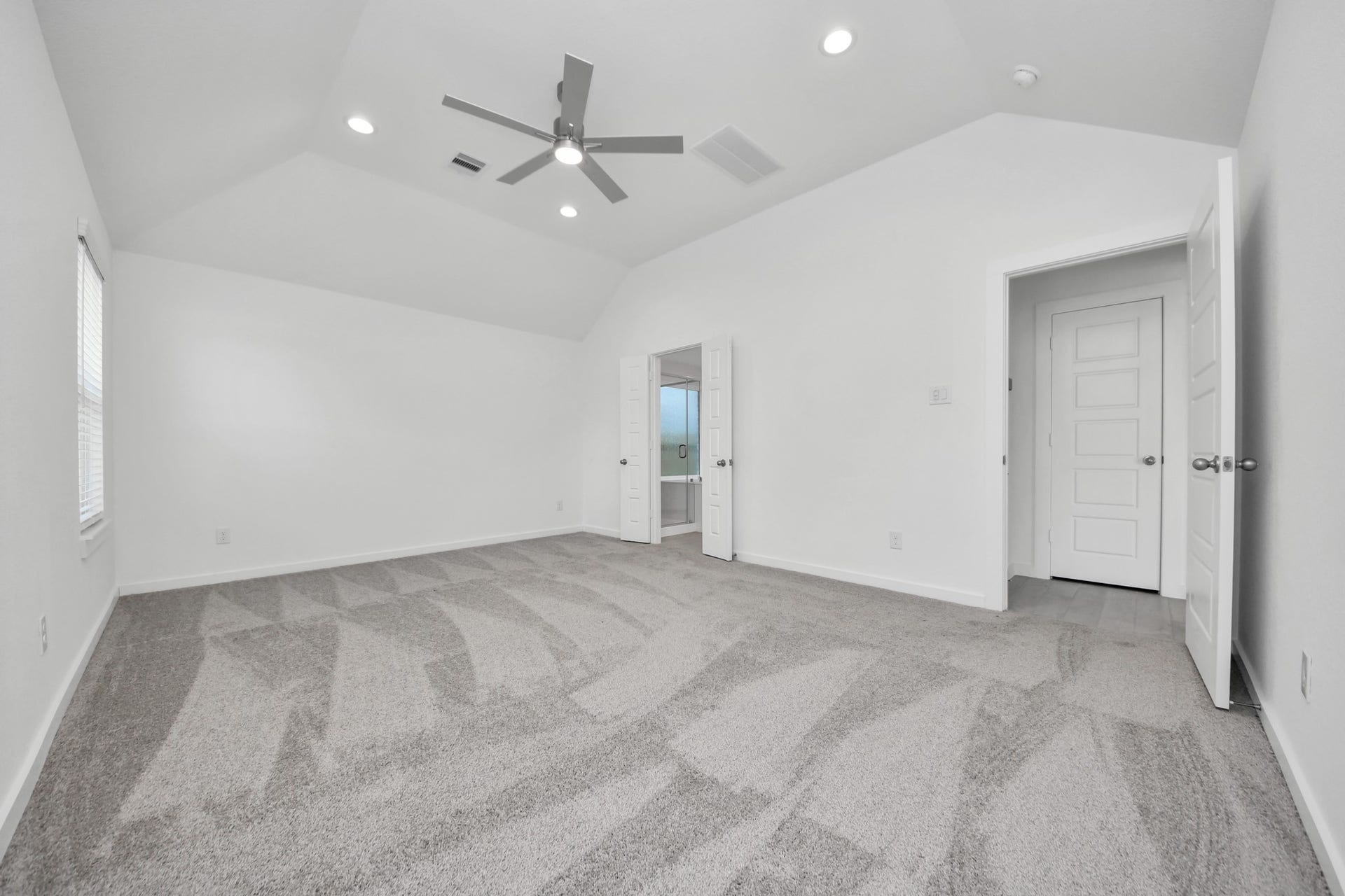 Escape and relax in the exquisite primary suite, a haven to unwind after a long day. The spacious room, boasts plush carpeting, soothing paint tones, high ceilings, and expansive windows adorned with privacy blinds. Sample photo of completed home with similar floor plan. Actual colors and selections may vary.