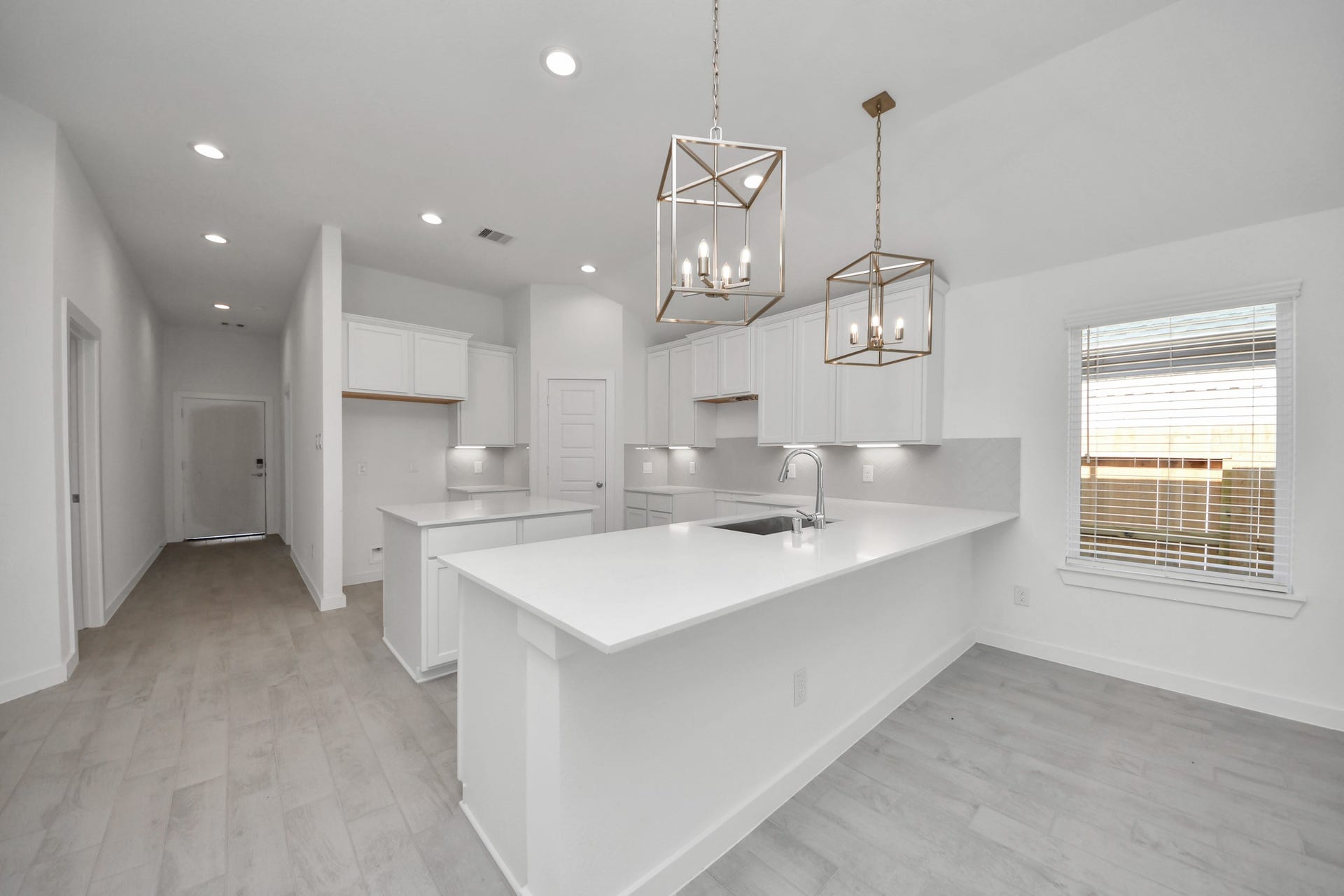 This kitchen is truly a chef's dream! This haven Boasts high ceilings, recessed & pendant lighting, stained wood cabinets, granite countertops, stainless steel appliances, a modern tile backsplash.  All of this overlooks your expansive family room, creating a perfect space for culinary delights and family gatherings. Sample photo of completed home with similar floor plan. Actual colors and selections may vary.