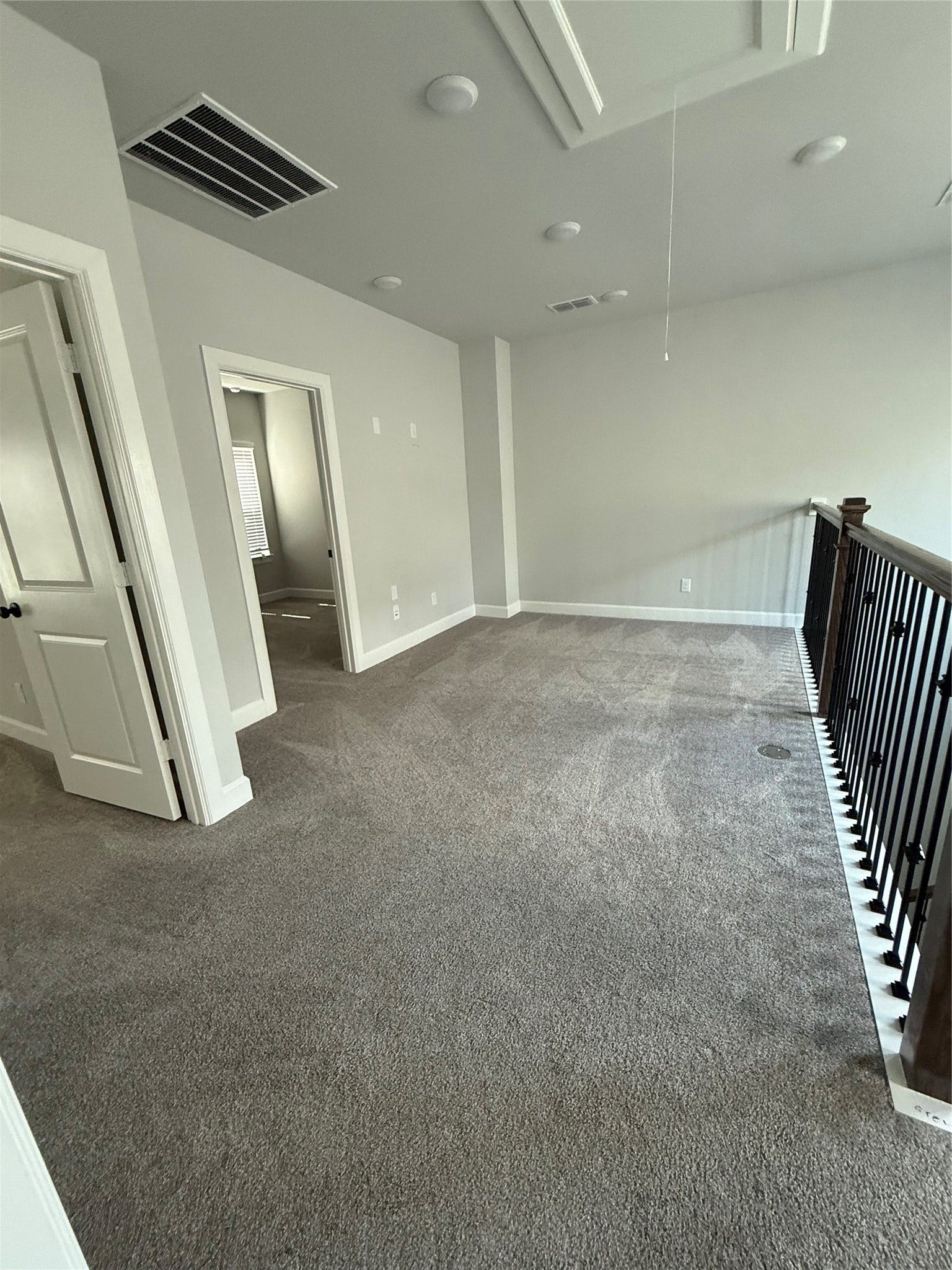 10526 William Park Drive, Missouri City, TX 77459 Spacious carpeted loft area with elegant railing, perfect for a cozy sitting nook or home office, adjacent to additional rooms for versatile use.