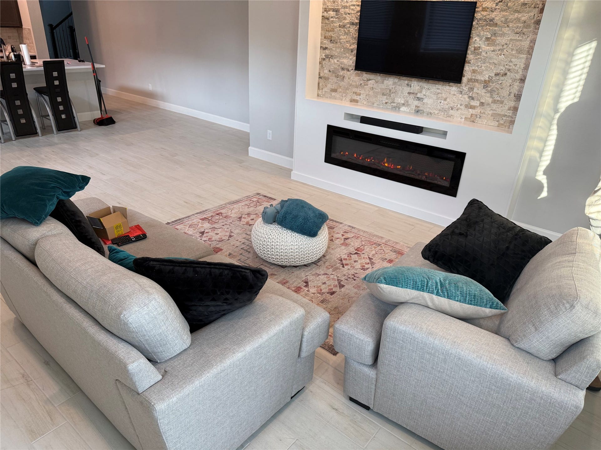 10526 William Park Drive, Missouri City, TX 77459 Modern living room featuring a sleek electric fireplace set in a textured stone wall, complemented by cozy seating and stylish decor.