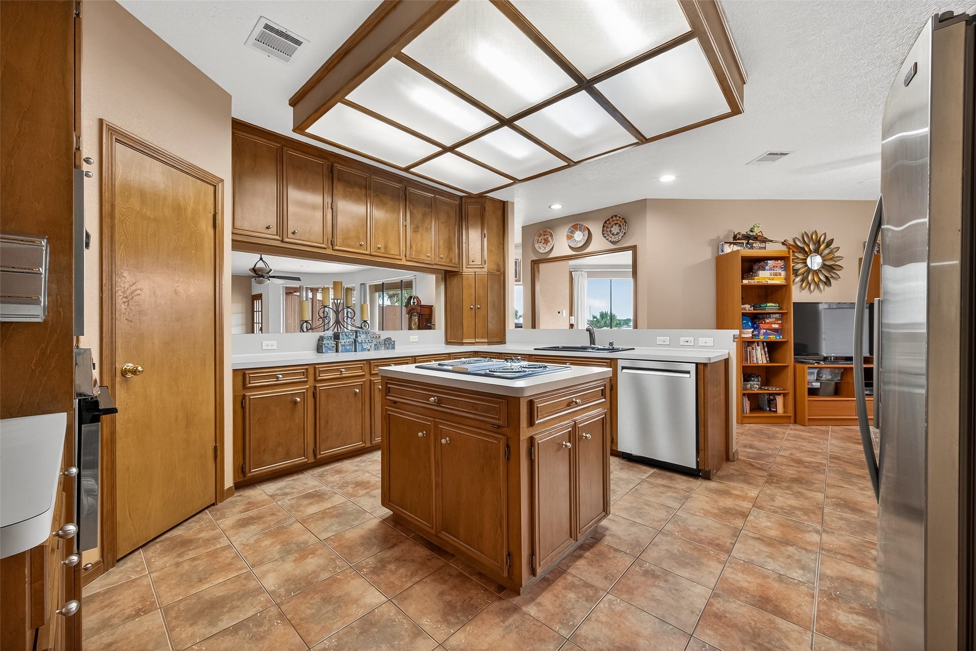 1623 Lake Arbor Drive, El Lago, TX 77586 ISLAND KITCHEN WITH A VIEW OF THE DEN AND THE LAKE IN THE BACKGROUND.