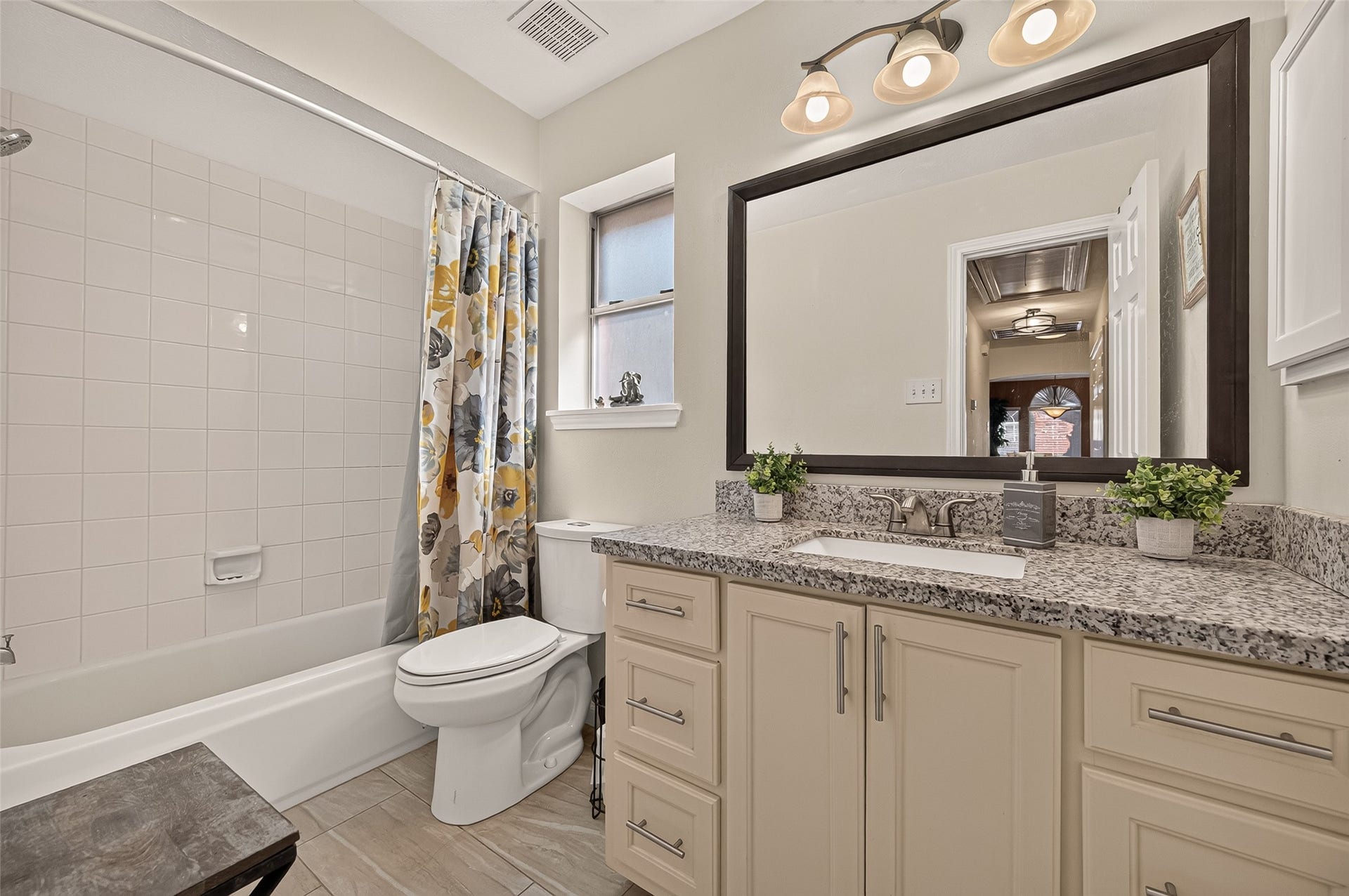 1615 Glacier Blue Drive, Fresno, TX 77545 Charming bathroom with a modern granite-topped vanity, elegant lighting, and a classic tub-shower combo accented..