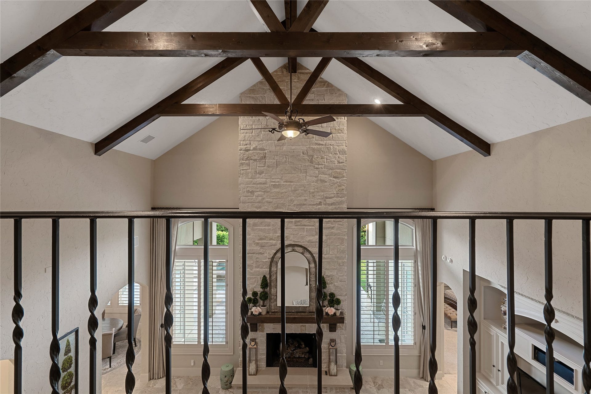75 S Player Crest Circle, The Woodlands, TX 77382 Beautiful Wood Beams Accent the Family Room Ceiling with Striking Wrought Iron Railing