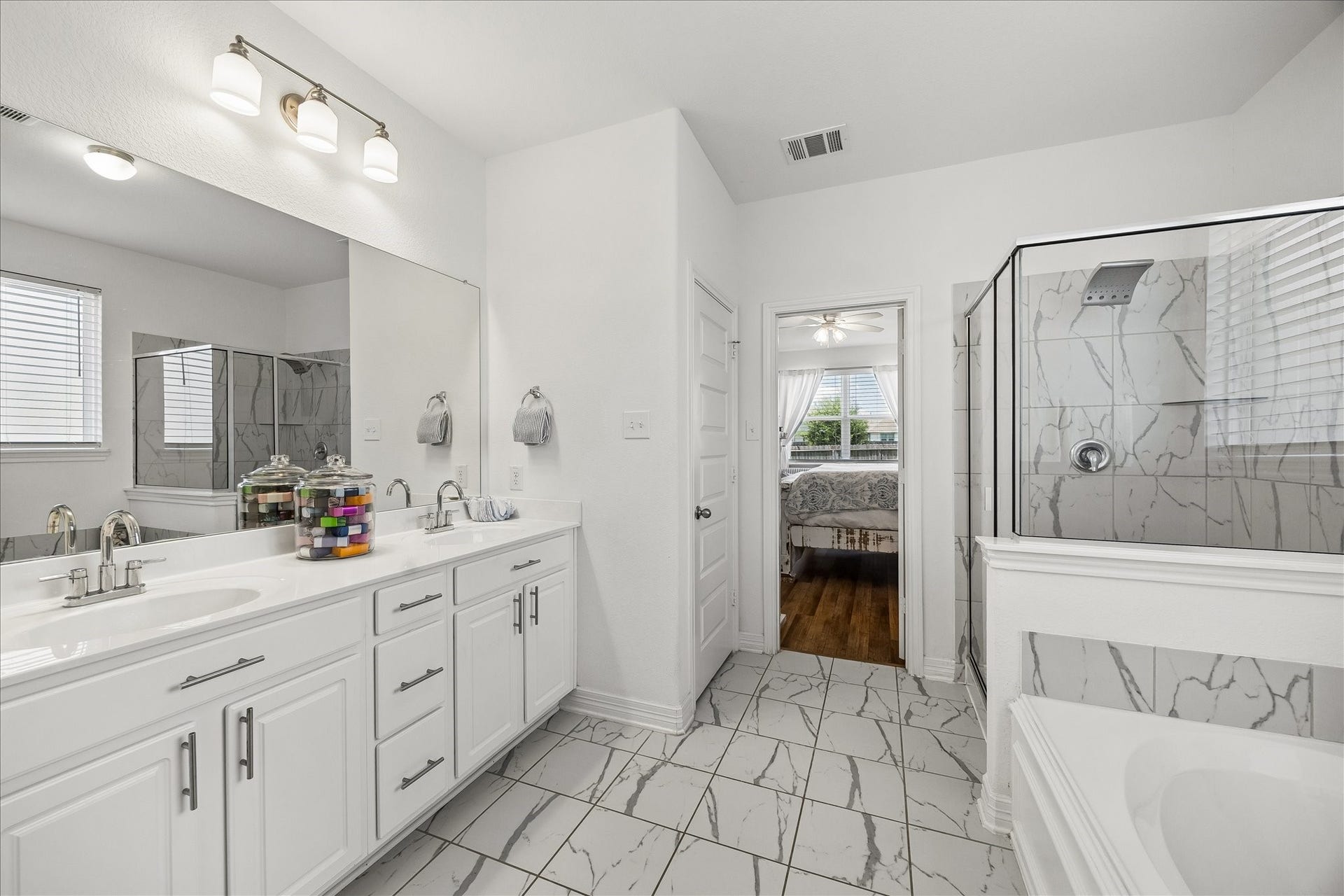 25934 Bronze Oak Court, Richmond, TX 77406 This bright, spa-like ensuite brings comfort and function together with a deep soaking tub, separate walk-in shower, dual sink vanity, marble look tile, linen storage, a private water closet and access to a large walk-in closet.