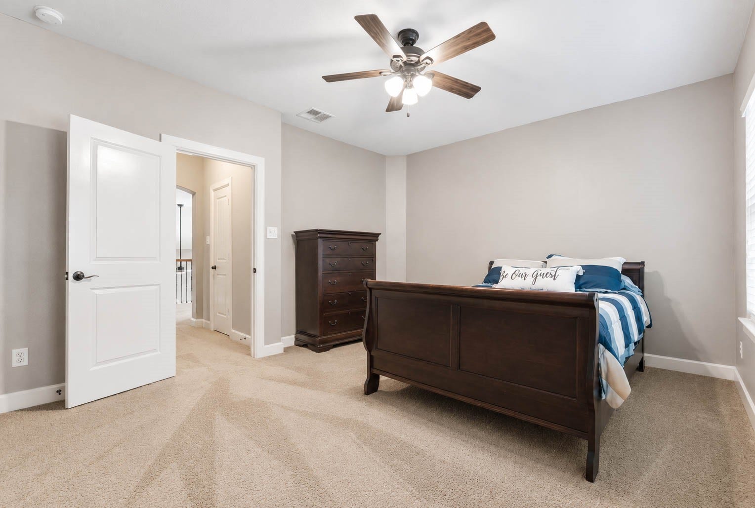 5331 W Farm Way, Fulshear, TX 77441 Guest bedroom number three offers a large window, a ceiling fan, plush carpet, and decorator paint, with plenty of room for a full bedroom set.