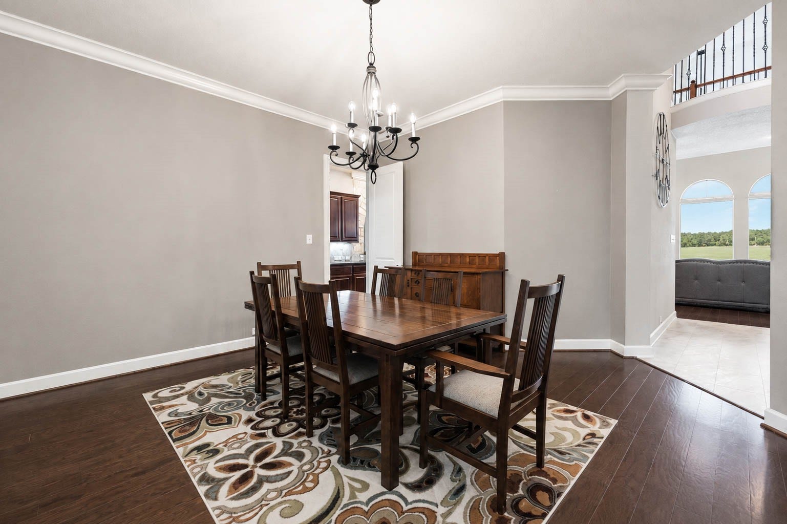 5331 W Farm Way, Fulshear, TX 77441 Continuing to the left of the foyer, the formal dining room features hardwood floors underfoot and a stunning wrought iron chandelier overhead, with easy access to the kitchen and living room.
