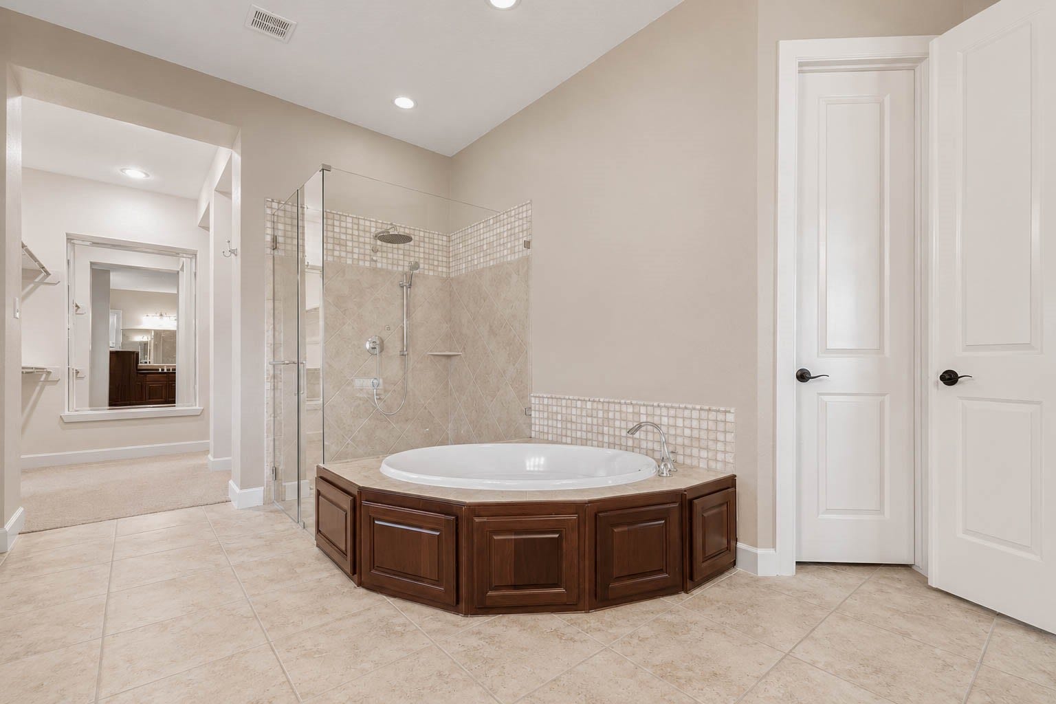 5331 W Farm Way, Fulshear, TX 77441 A closer look at the soaking tub and spacious walk in shower, featuring a frameless glass enclosure, neutral tile surround, and elegant detailing throughout.