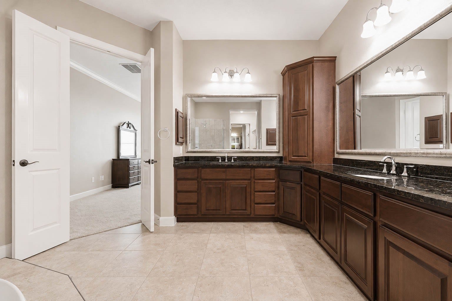 5331 W Farm Way, Fulshear, TX 77441 This primary bathroom offers abundant space, featuring a massive dual sink vanity with framed mirrors, granite countertops, and plenty of cabinets and drawers for towels and toiletries.