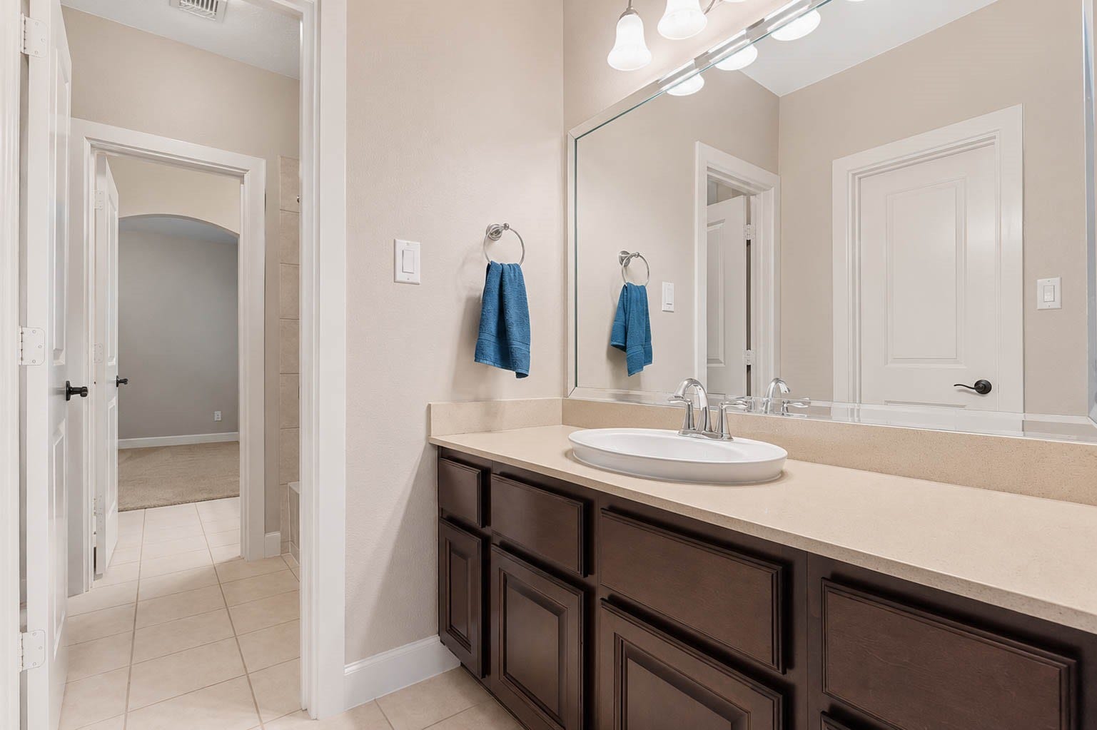 5331 W Farm Way, Fulshear, TX 77441 This Hollywood bathroom off the guest bedroom offers a spacious vanity with espresso stained cabinetry, a framed mirror, and updated fixtures.