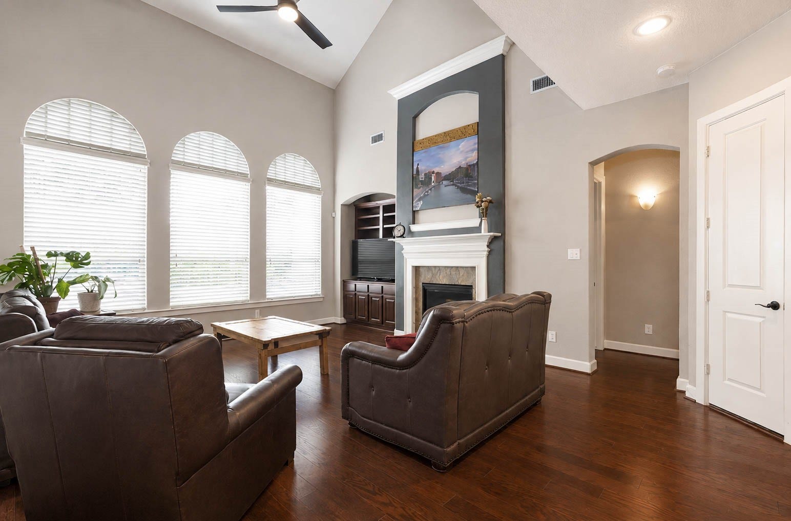 5331 W Farm Way, Fulshear, TX 77441 The living room impresses with soaring vaulted ceilings, hardwood floors, and an eye catching fireplace framed in a beautiful accent tile, all beneath a wall of arched windows overlooking the backyard.