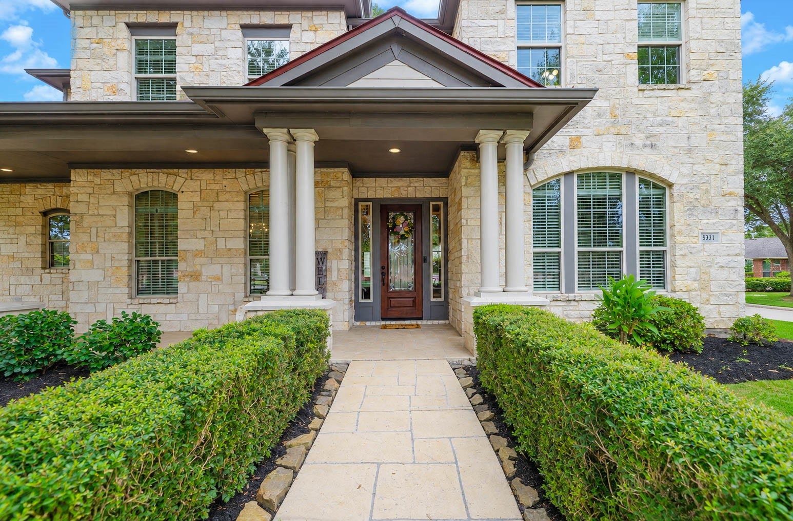 5331 W Farm Way, Fulshear, TX 77441 A landscaped pathway lined with manicured shrubs leads to the covered front porch, where a leaded glass front door flanked by matching side windows brings natural light into the foyer.