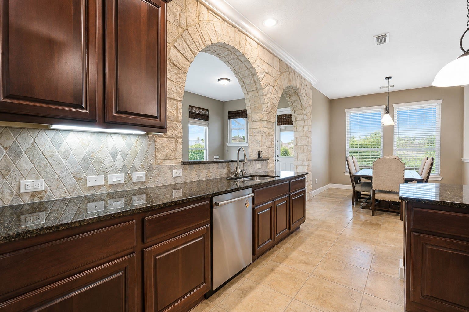 5331 W Farm Way, Fulshear, TX 77441 Under cabinet lighting and a full wall of cabinetry provide added storage, while the sink and dishwasher sit beneath a breakfast bar, making it easy to converse while prepping meals or cleaning up.