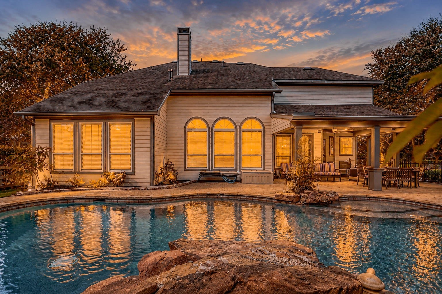 5331 W Farm Way, Fulshear, TX 77441 The backyard is a true oasis, featuring a covered patio, a 21,100 gallon heated gunite pool and spa with a dramatic stacked stone waterfall, and lush mature landscaping throughout.