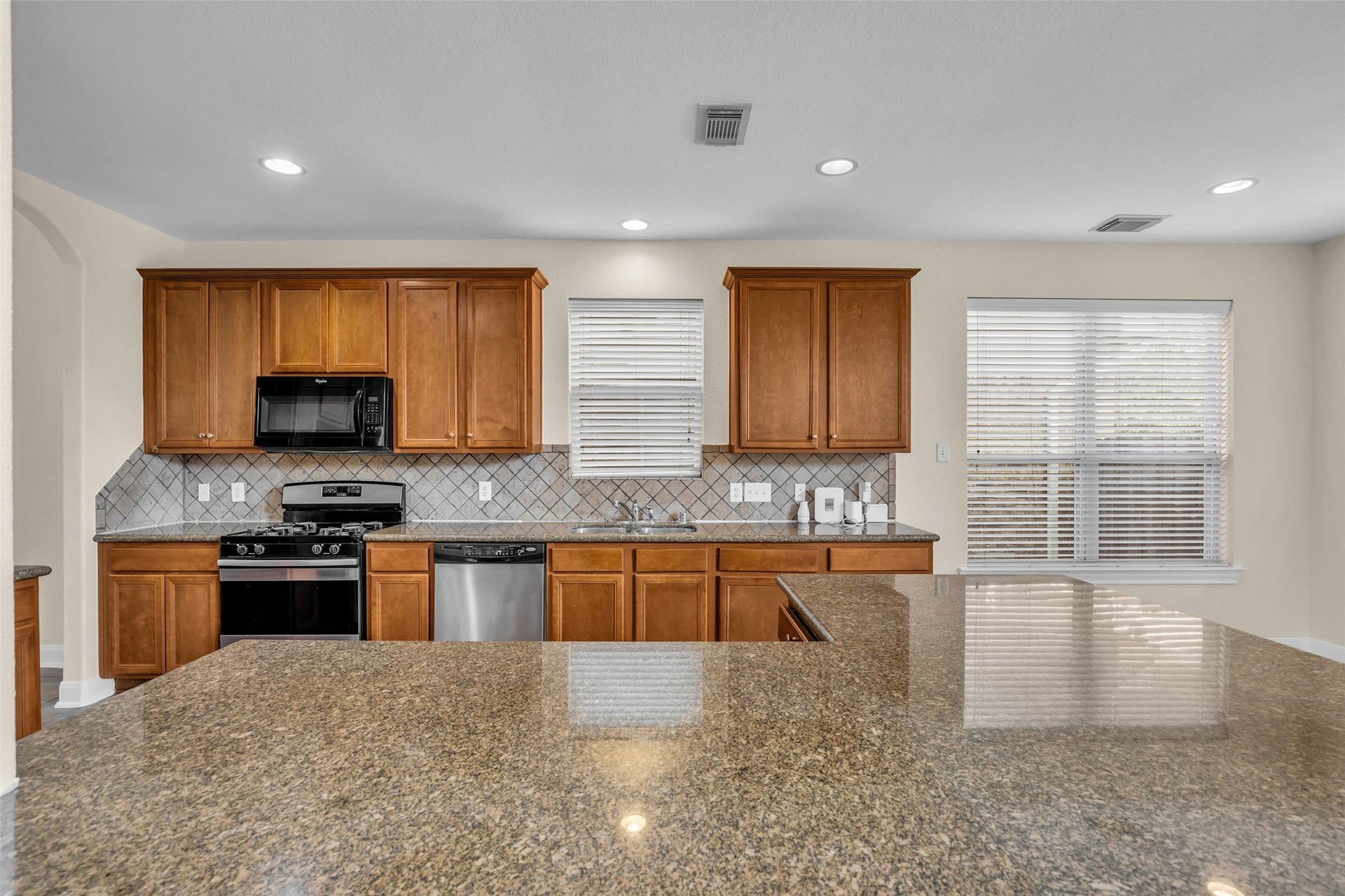 9907 Heritage Waters Court, Humble, TX 77396 The kitchen features generous abundant cabinetry, sleek granite counters and convenient breakfast bar.