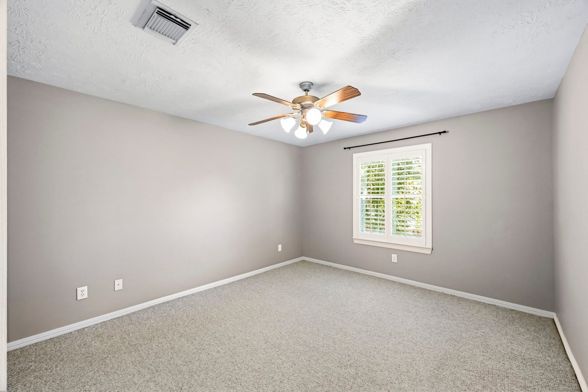 951 Lamonte Lane, Houston, TX 77018 Bright secondary bedroom with Berber carpet, ceiling fan, and plantation shutters.