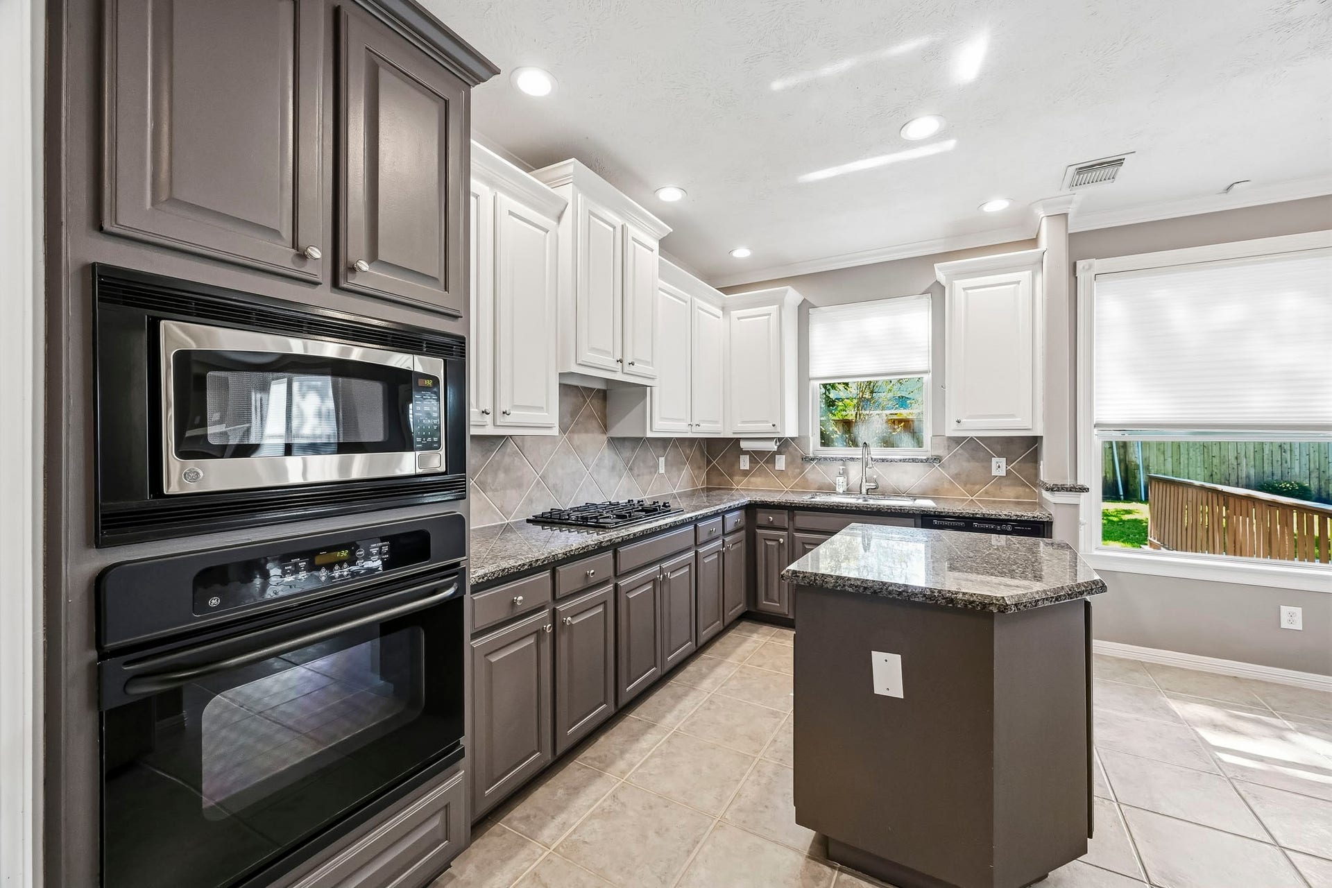 951 Lamonte Lane, Houston, TX 77018 Spacious kitchen with granite countertops, center island, abundant cabinetry, tile backsplash, and built-in appliances.