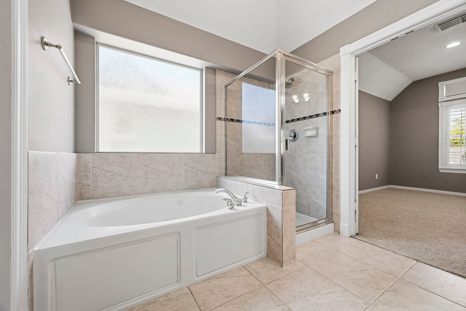 951 Lamonte Lane, Houston, TX 77018 Relax in the primary bathroom's jetted soaking tub, complemented by a separate glass-enclosed shower and natural light.