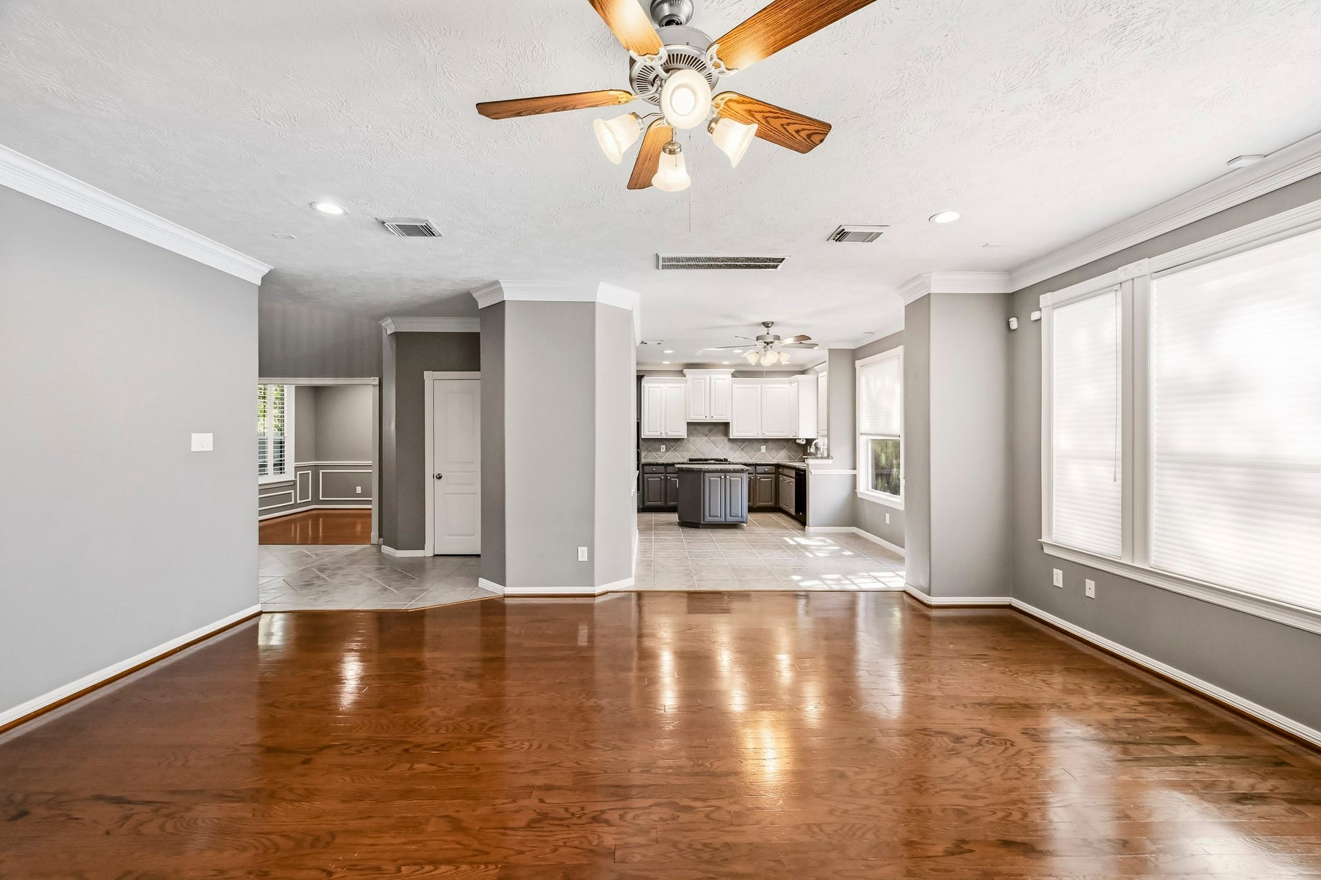 951 Lamonte Lane, Houston, TX 77018 Spacious family room with hardwood floors, crown molding, and ceiling fan. Open layout connects the living space to the kitchen and breakfast area.