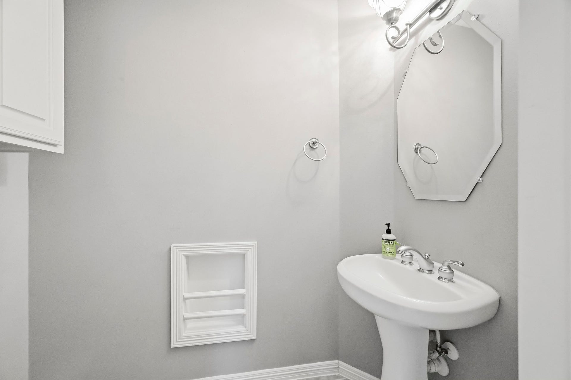 951 Lamonte Lane, Houston, TX 77018 Convenient downstairs powder room featuring a pedestal sink, decorative mirror, and neutral finishes.