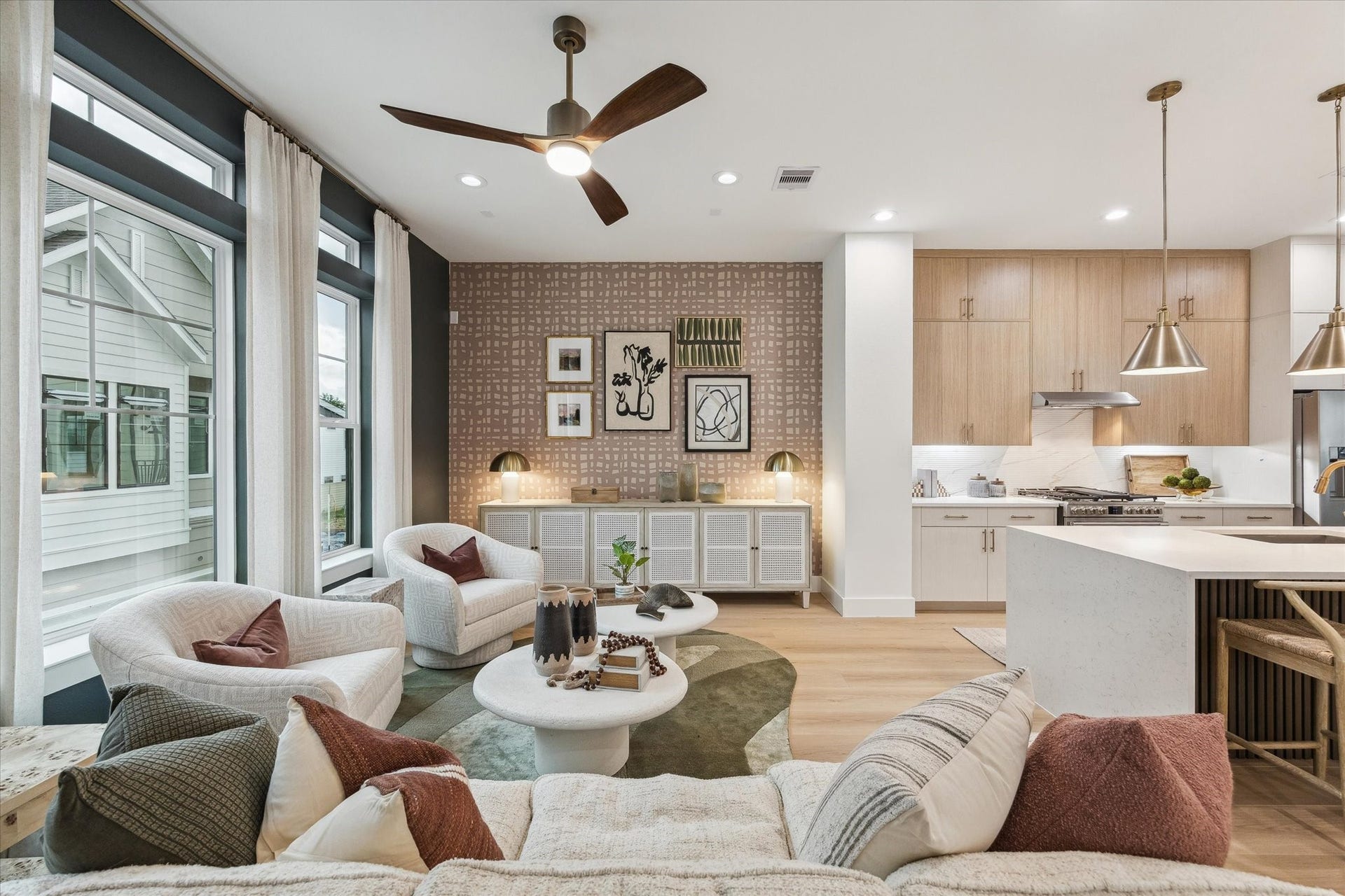 Spacious open-concept living area with large windows, modern kitchen, and stylish decor, perfect for entertaining.