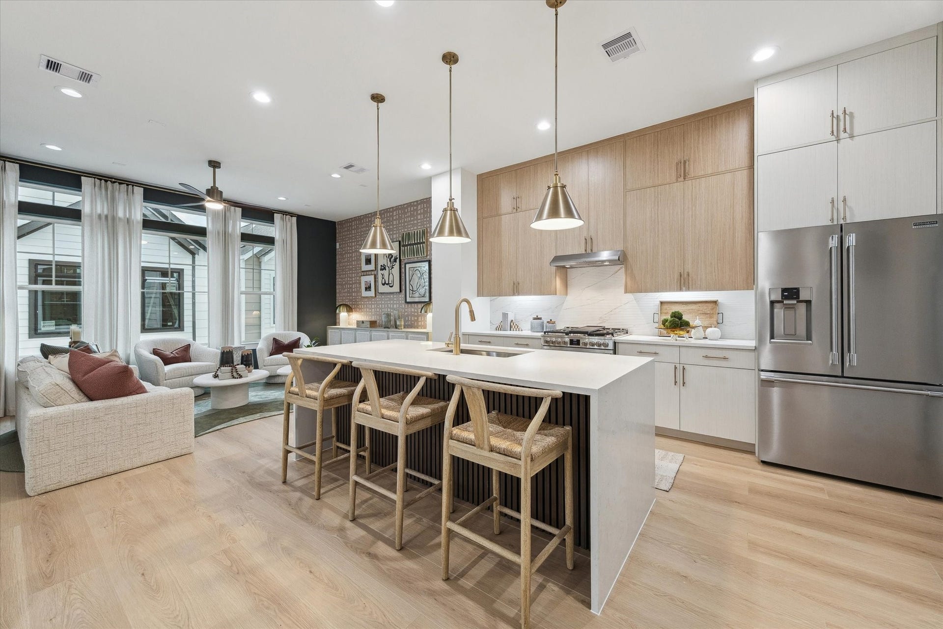 Stunning open-concept kitchen and living area featuring sleek cabinetry, a spacious island with seating, modern appliances, and abundant natural light.