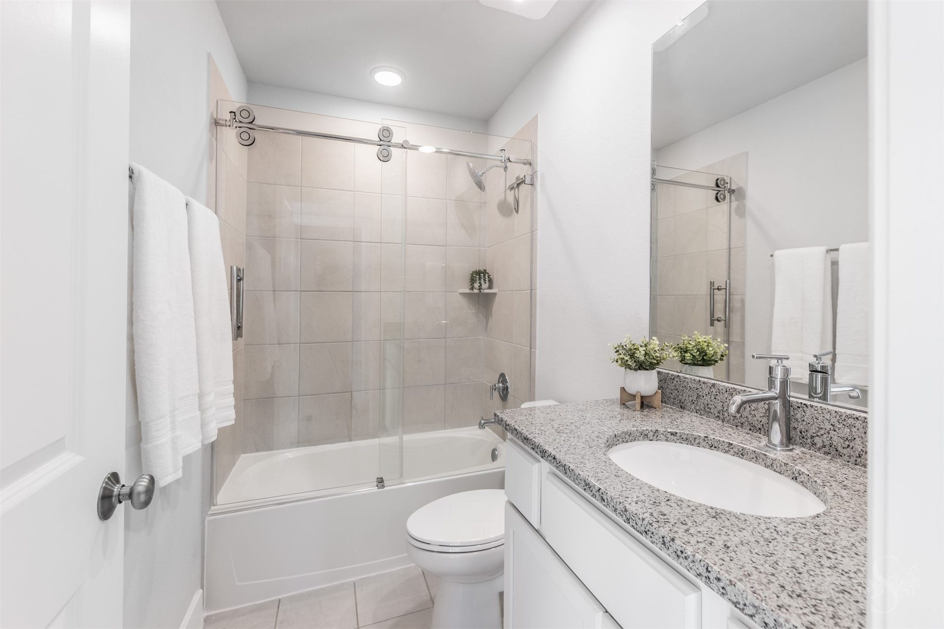 20922 Maudine Drive, Cypress, TX 77433 The upstairs bath features a beautiful granite vanity with white cabinetry and a polished chrome faucet. A tiled tub and shower combination with sliding glass doors offers everyday convenience for the family.