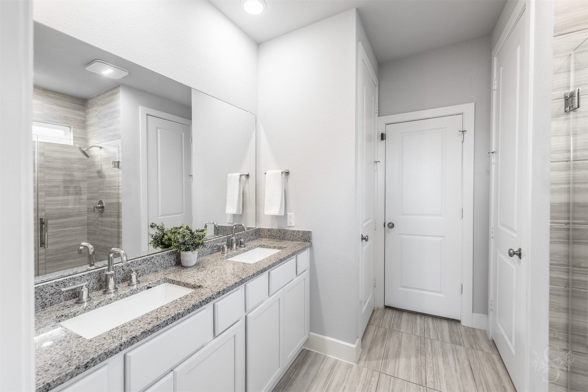 20922 Maudine Drive, Cypress, TX 77433 The beautiful primary bath features an extended vanity with dual sinks, granite counters and crisp white cabinetry. Coordinating tile flooring and a spacious glass-enclosed shower create an elegant setting for your daily routine.