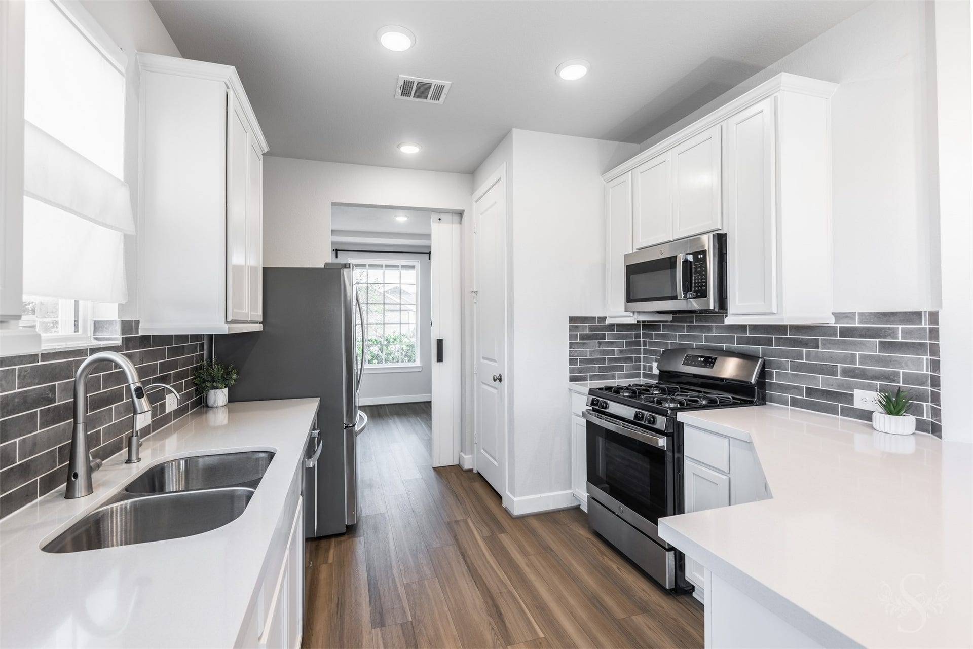 20922 Maudine Drive, Cypress, TX 77433 A stainless steel gas range and built-in microwave complement the kitchens beautiful white cabinetry and quartz counters. Generous counter space, a double-basin sink and abundant cabinet storage make meal preparation a pleasure.