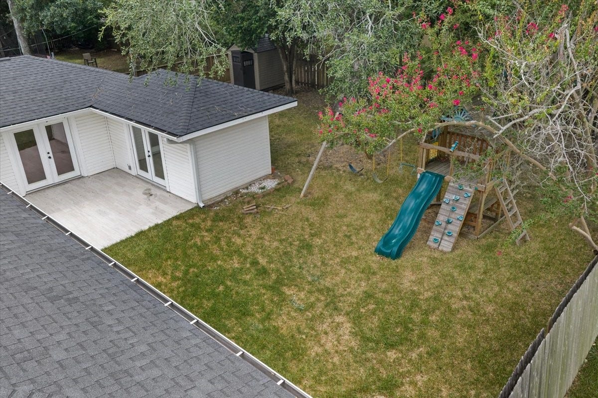11510 Mullins Drive, Houston, TX 77035 Expansive backyard with a charming play set and a spacious patio, perfect for family gatherings and outdoor enjoyment.