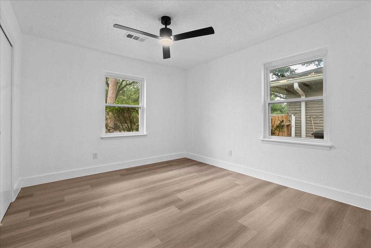 11510 Mullins Drive, Houston, TX 77035 Bright and inviting room with natural light, featuring sleek wood flooring and a modern ceiling fan.